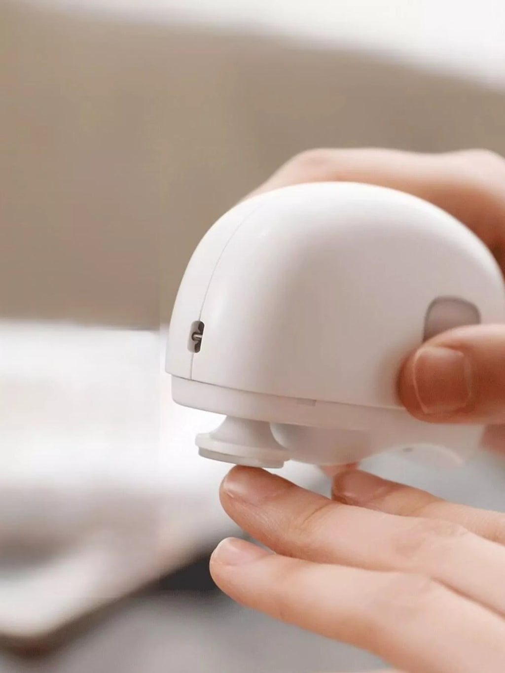 White electric nail buffer with power button and grip handle in hand