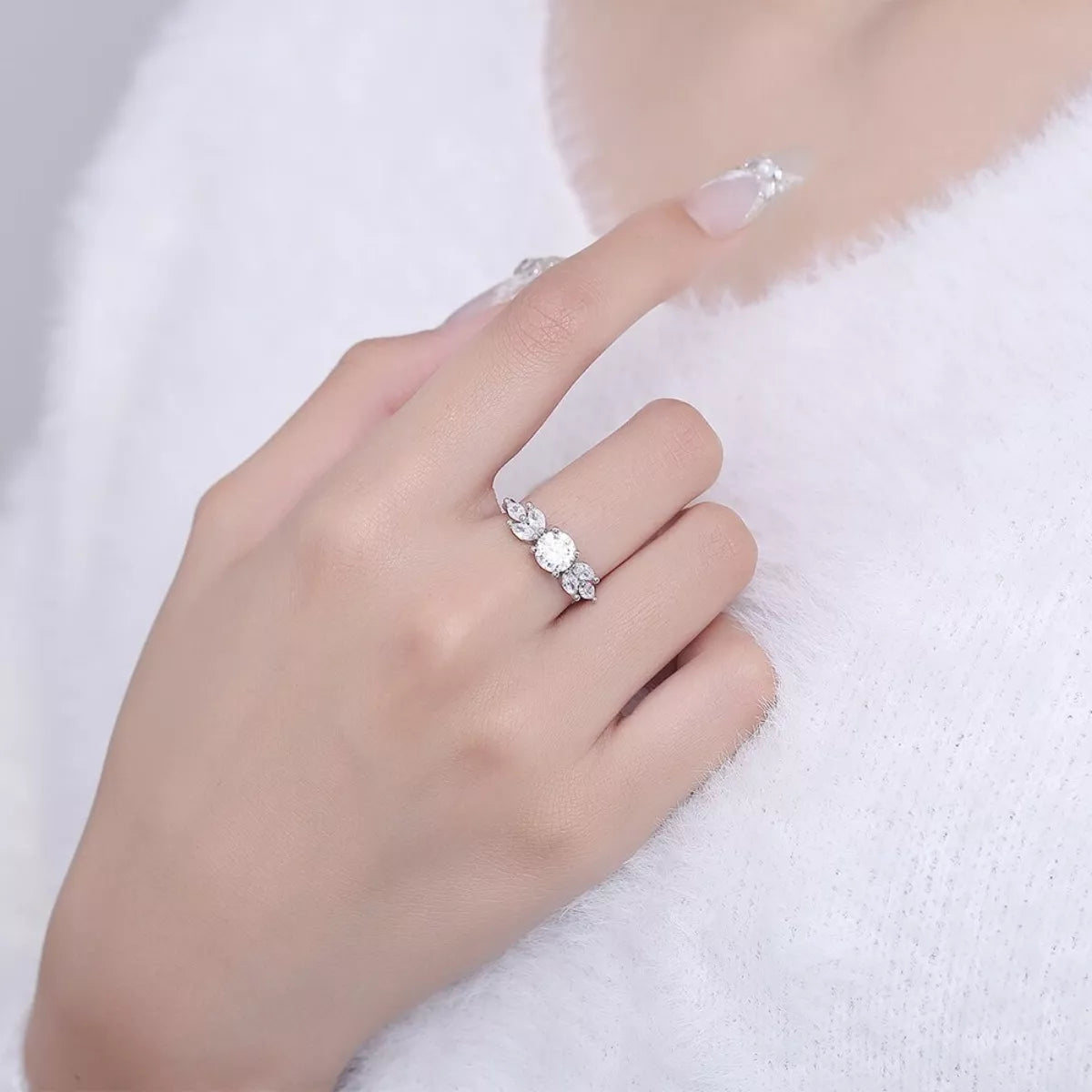 Moissanite ring with three oval stones on 925 sterling silver band, worn on hand