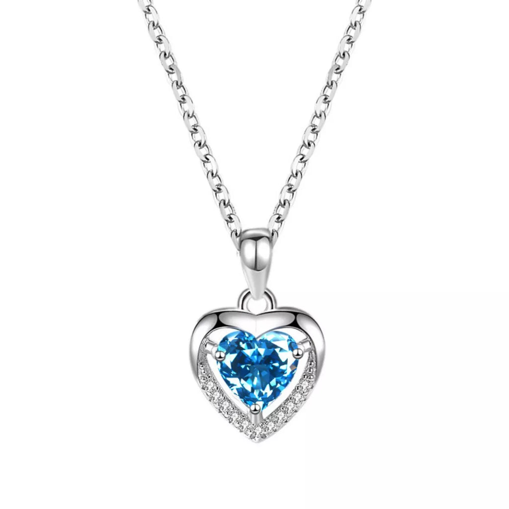 Silver heart pendant close-up with light blue zircon and pavé halo frame