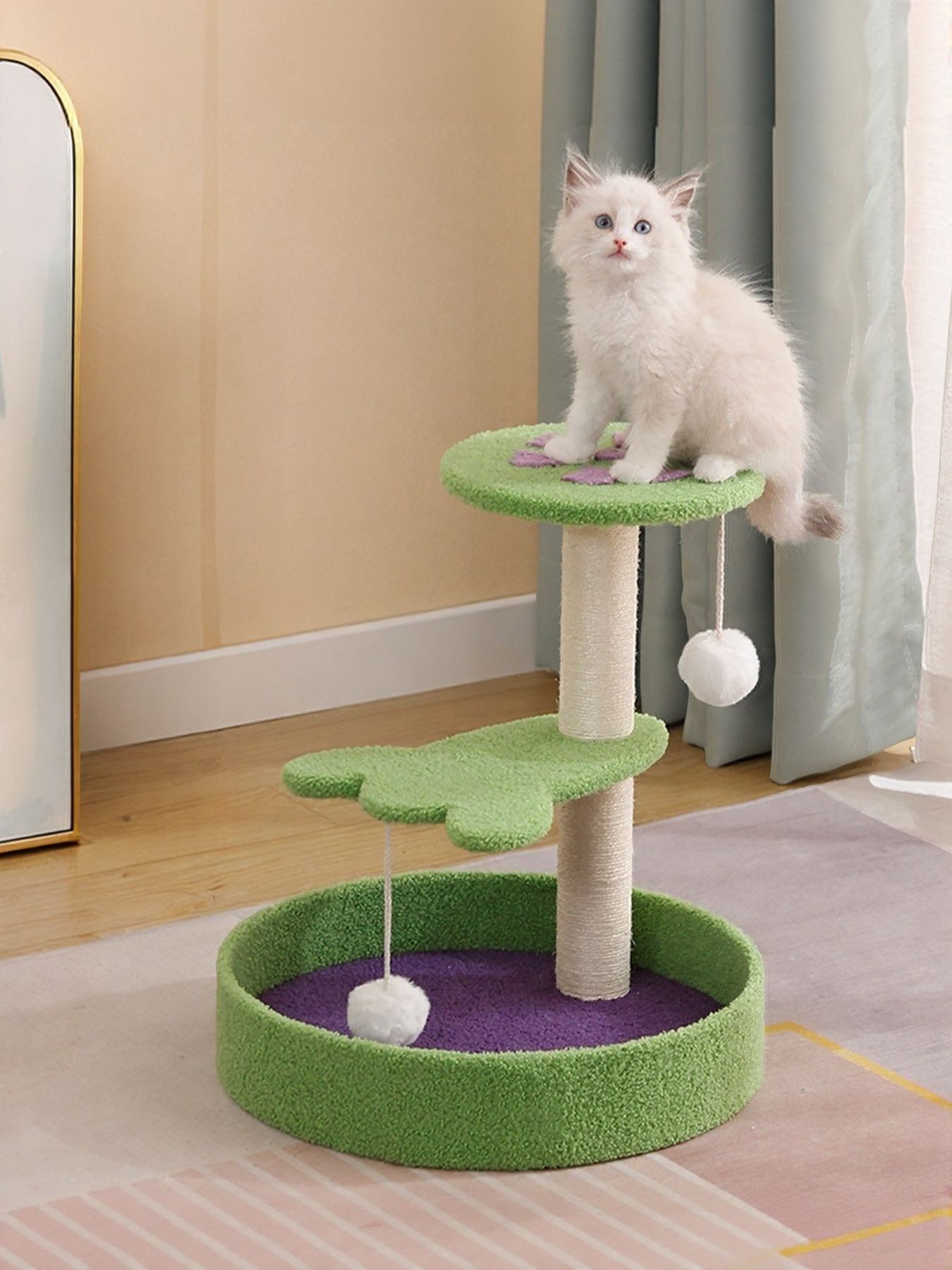 Green cat scratching post with purple base, plush bed and dangling ball toy