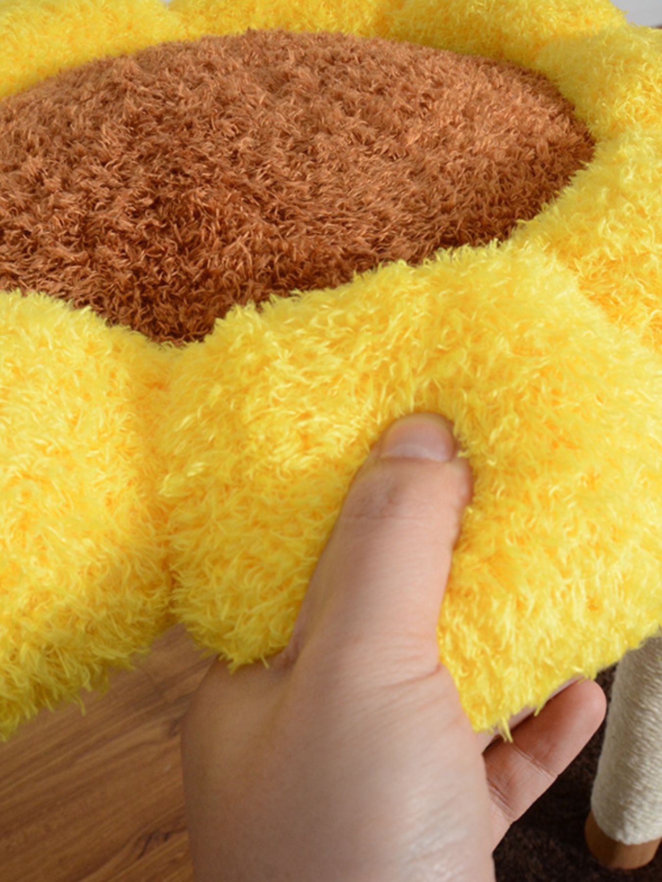 Tejido mullido amarillo y centro marrón en la cama tipo girasol