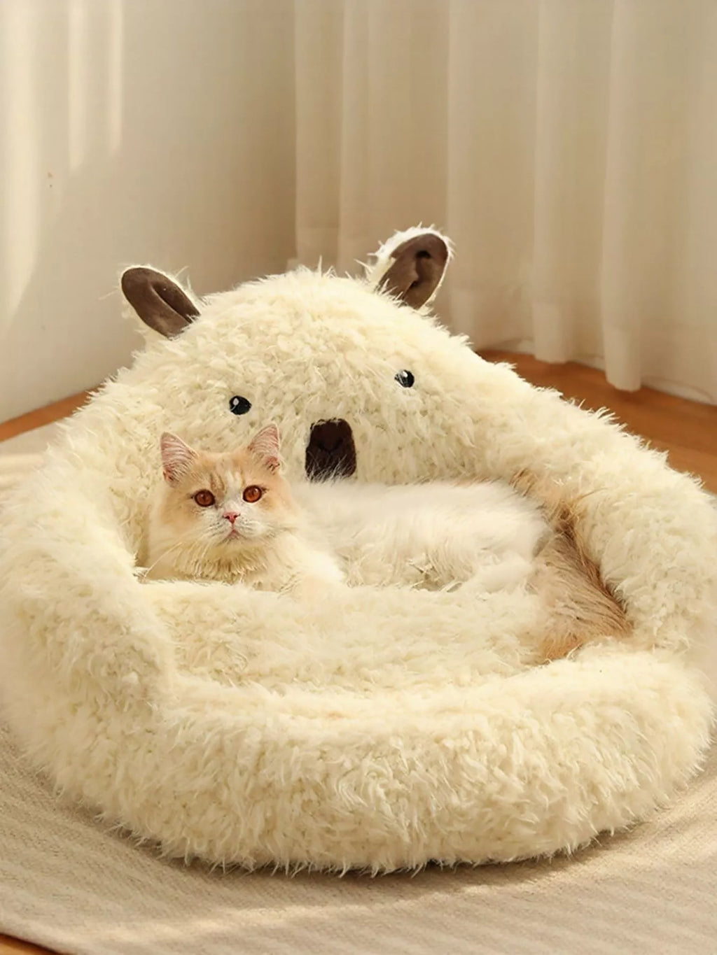 Bear-shaped cream plush pet nest with kitten resting in the center