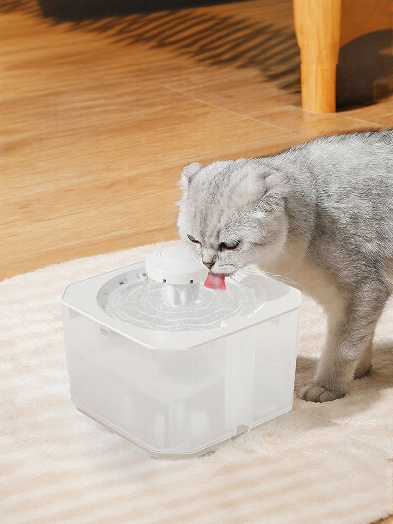 Pet water fountain with white nozzle, transparent reservoir box and water flow