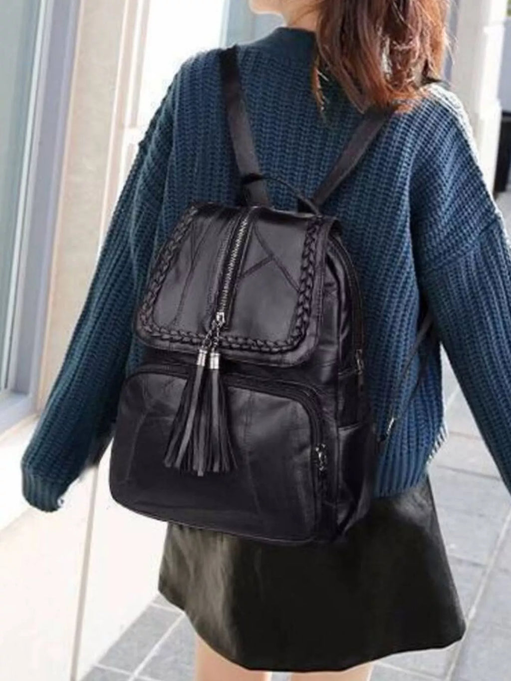 Black leather backpack bag with braided trim front flap and tassel detail