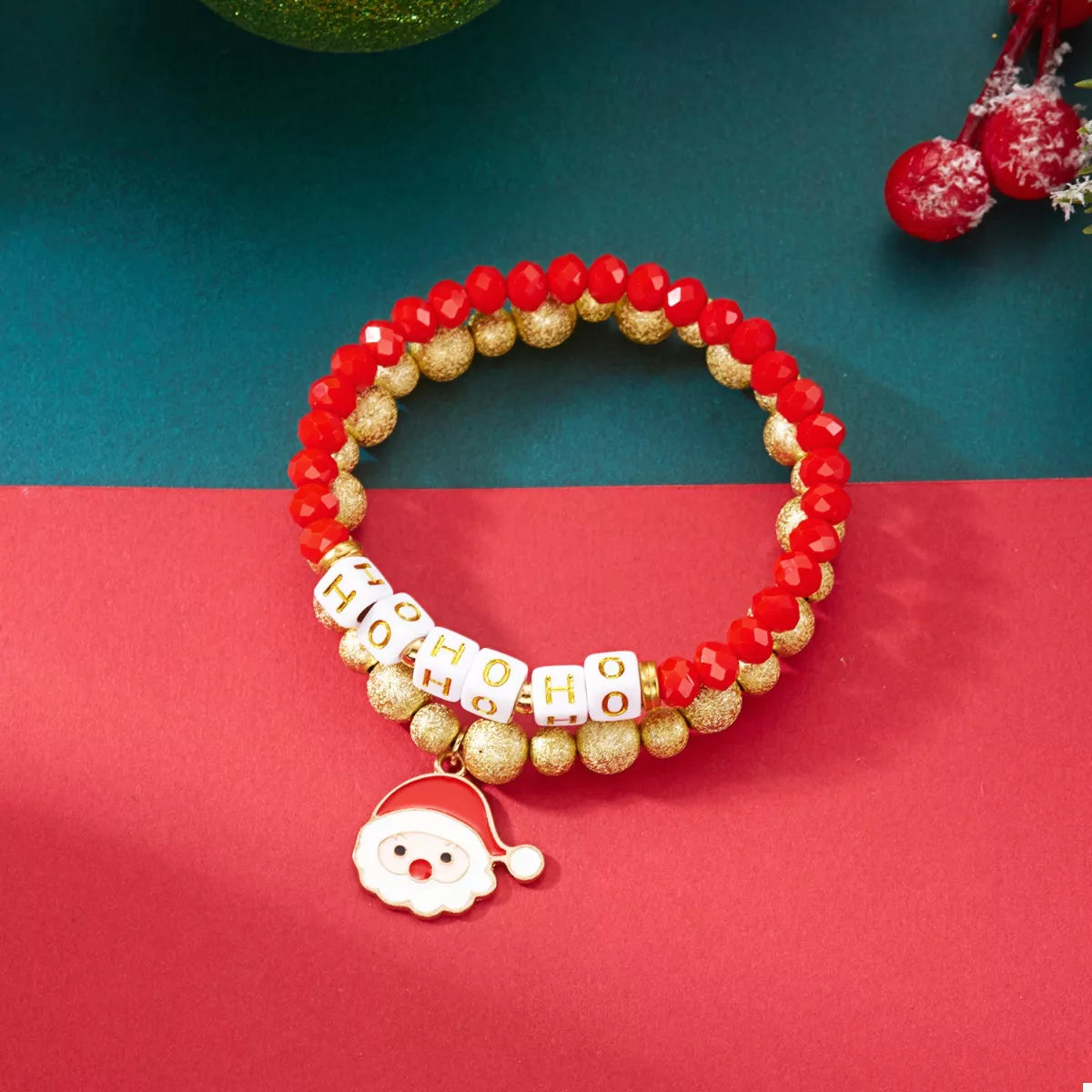 Close-up red faceted bead bracelet with gold balls, HO HO HO beads, Santa charm