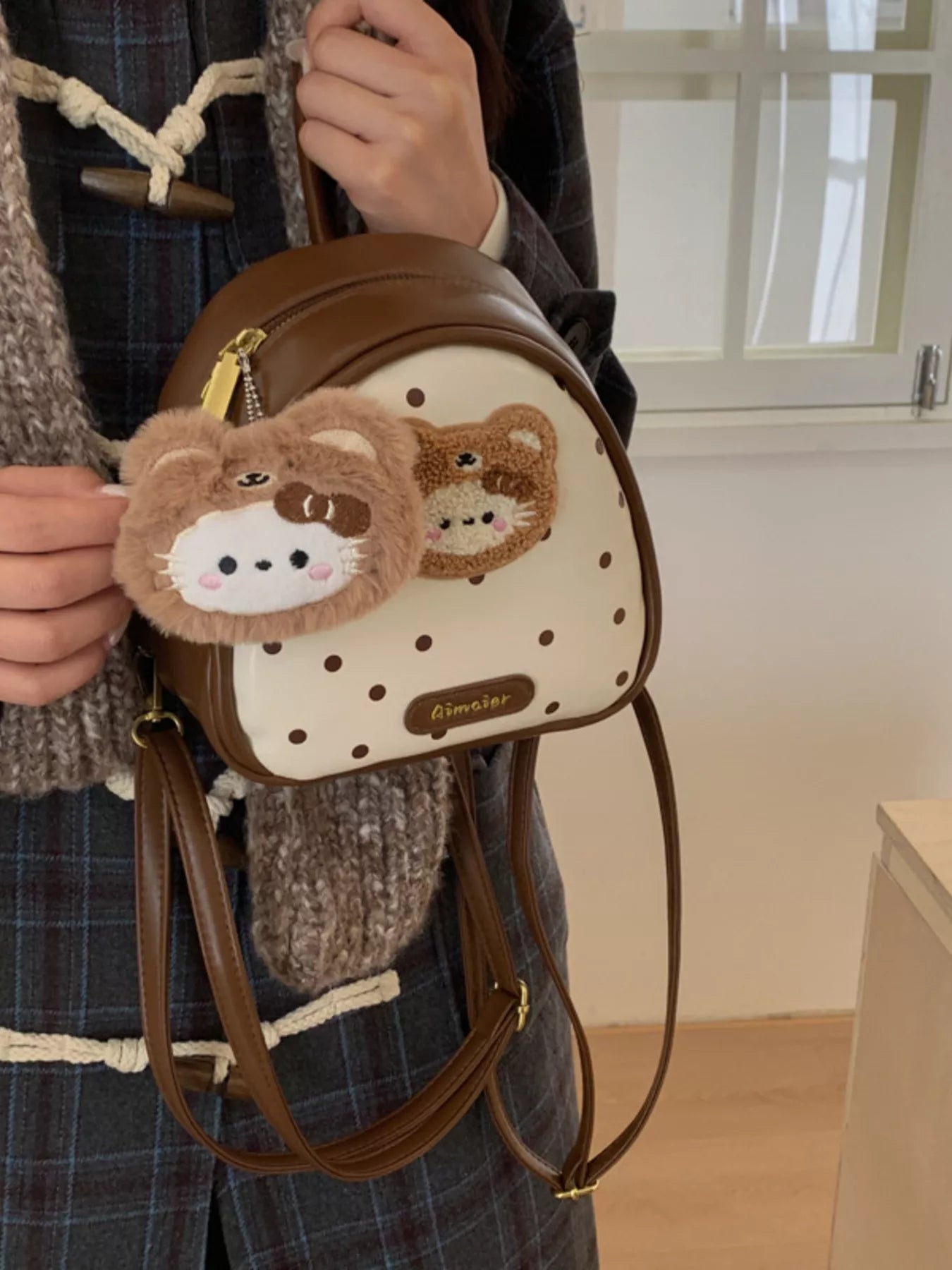 Cartoon Bear Backpack Bag on person: brown mini backpack with bear keychain and stitched front