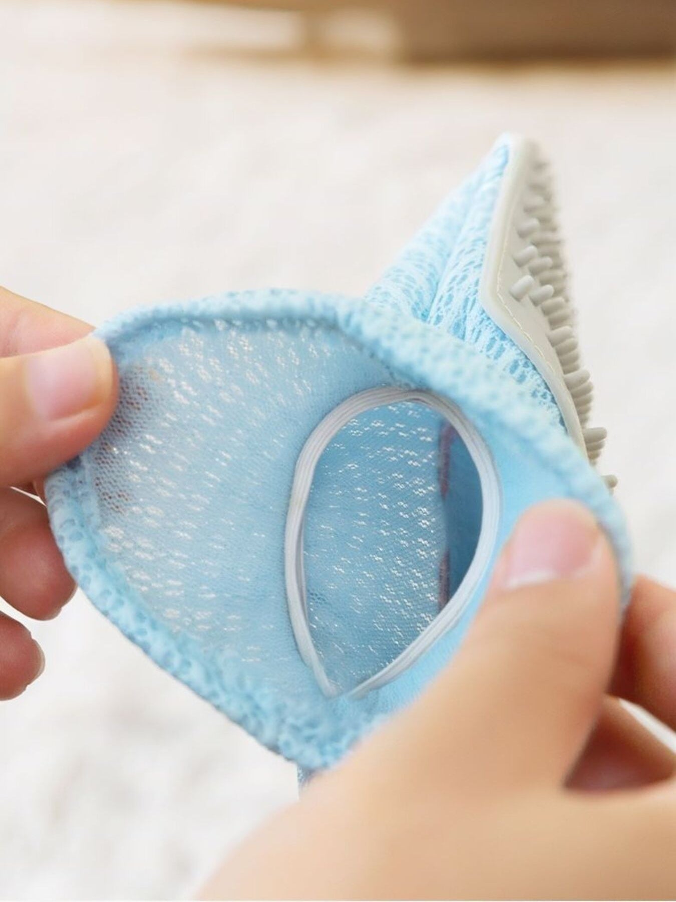 Underside close-up of blue pet hair remover glove with bristle pad