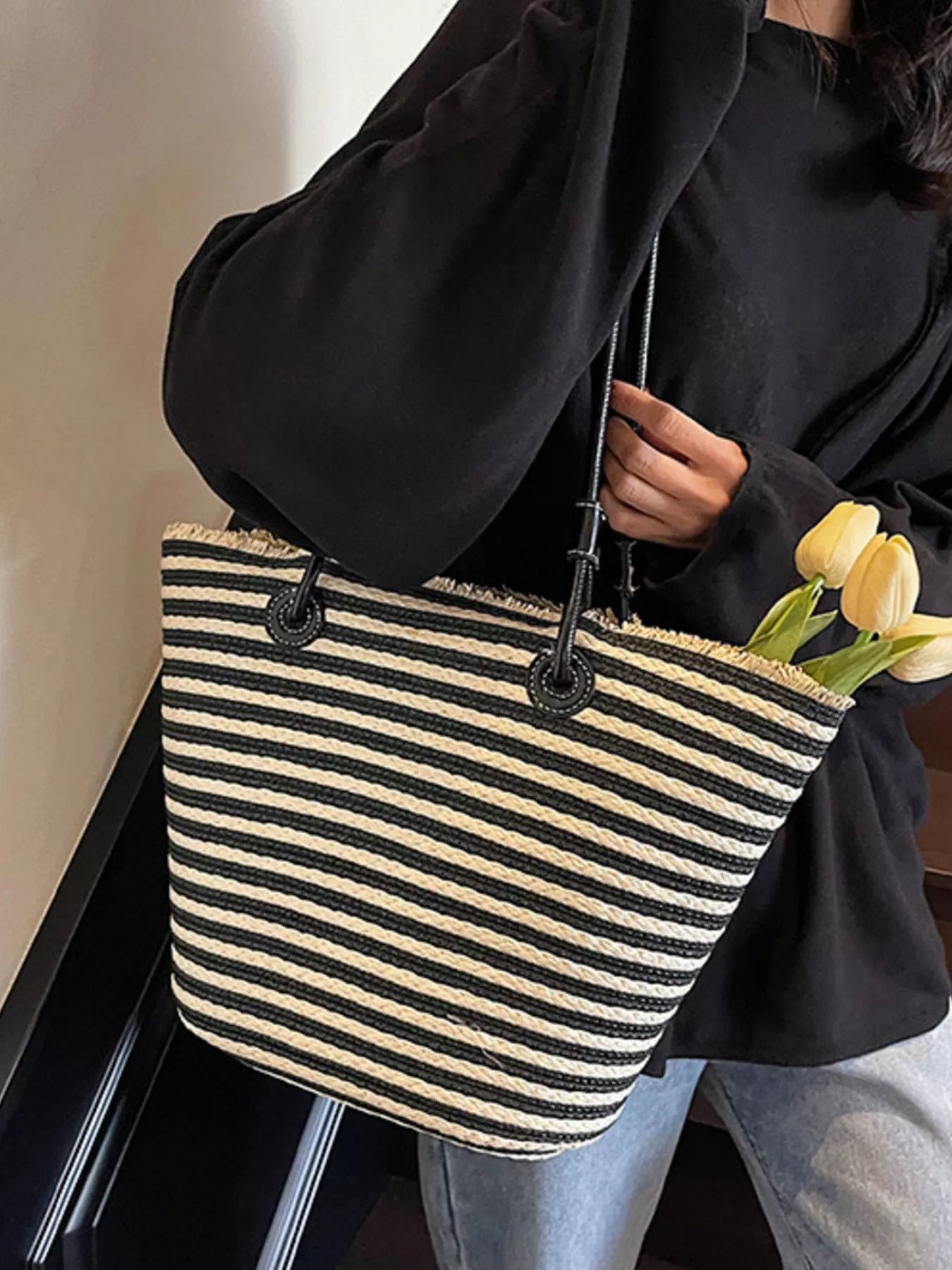Striped woven straw shoulder bag with black handles and side opening look