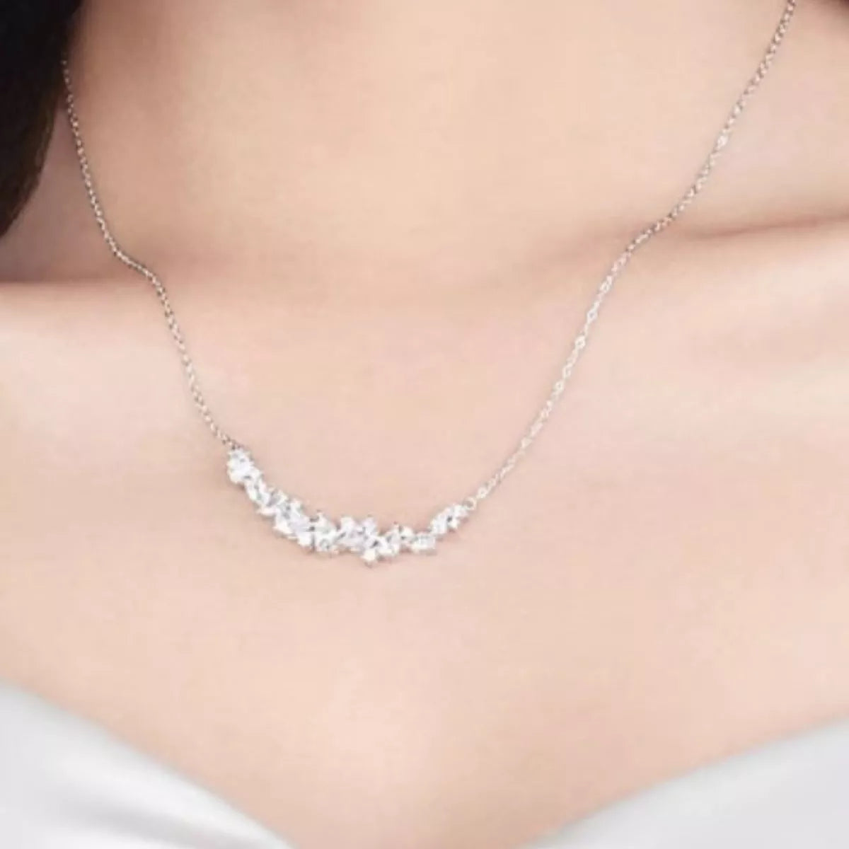 Silver zircon necklace on skin, oval and marquise stones in a curved row