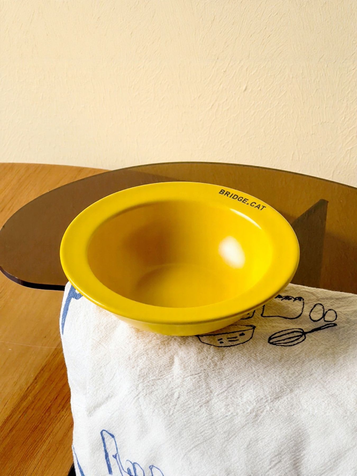 Bright yellow pet bowl with “BRIDGE·CAT” text on the rim