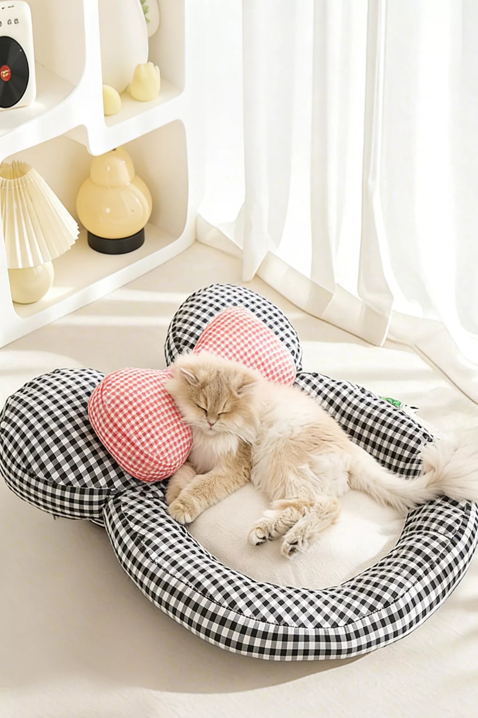 Plaid pet bed with red check bow pillow, resting kitten curled in cushion