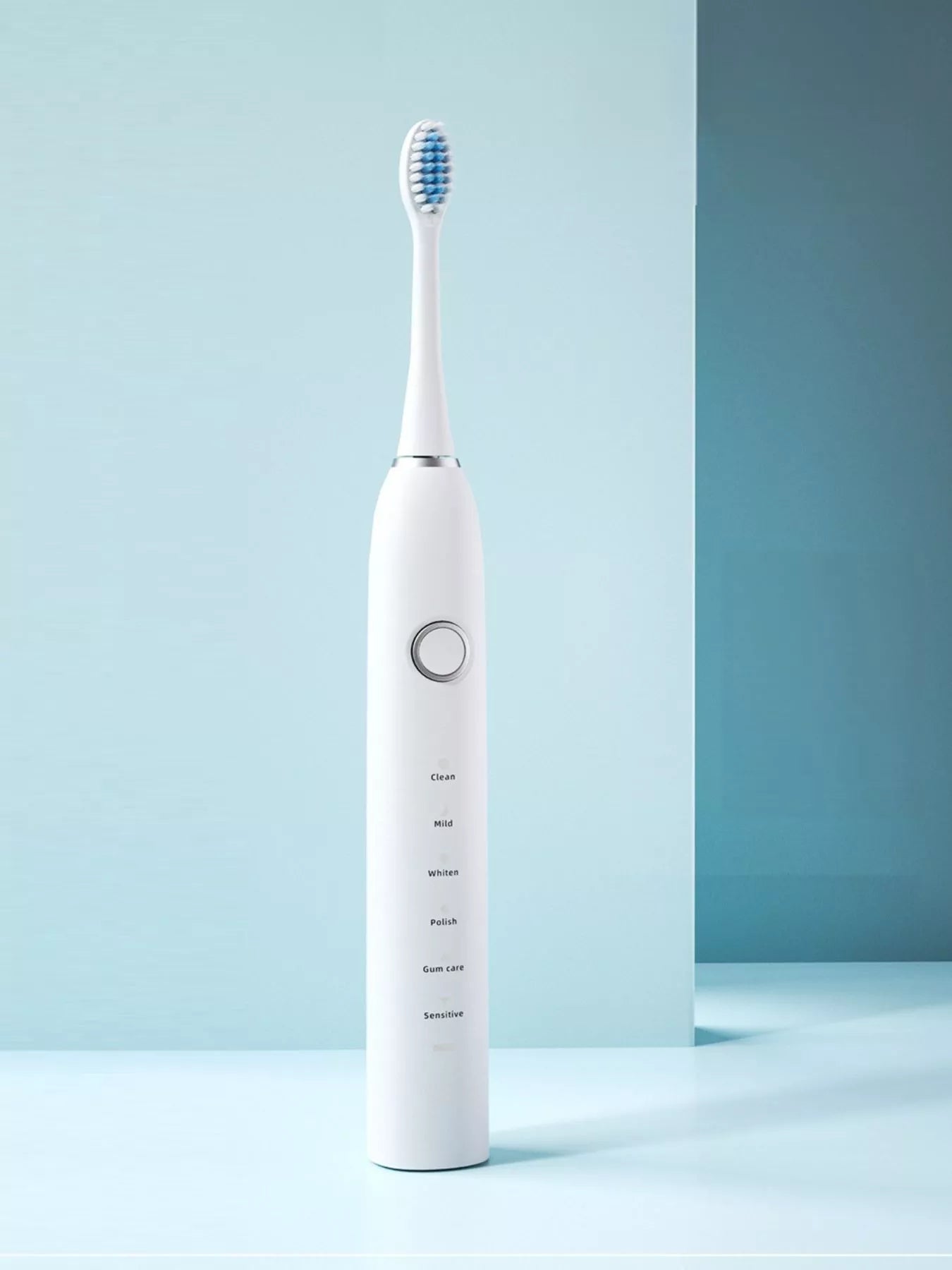White electric toothbrush with blue bristles and mode labels on handle