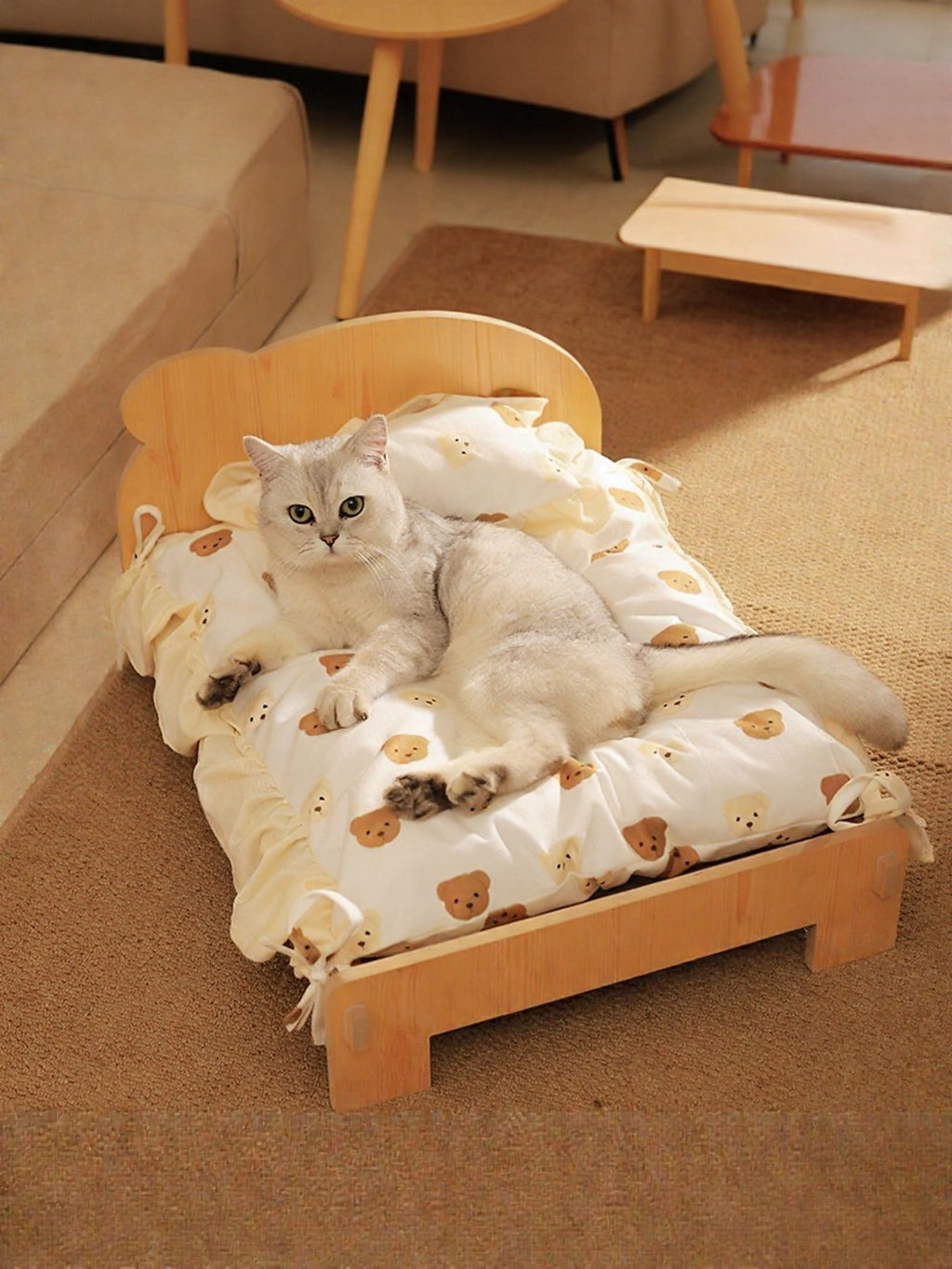 Wooden pet bed with raised sides and white bear-pattern bedding, cat resting inside.