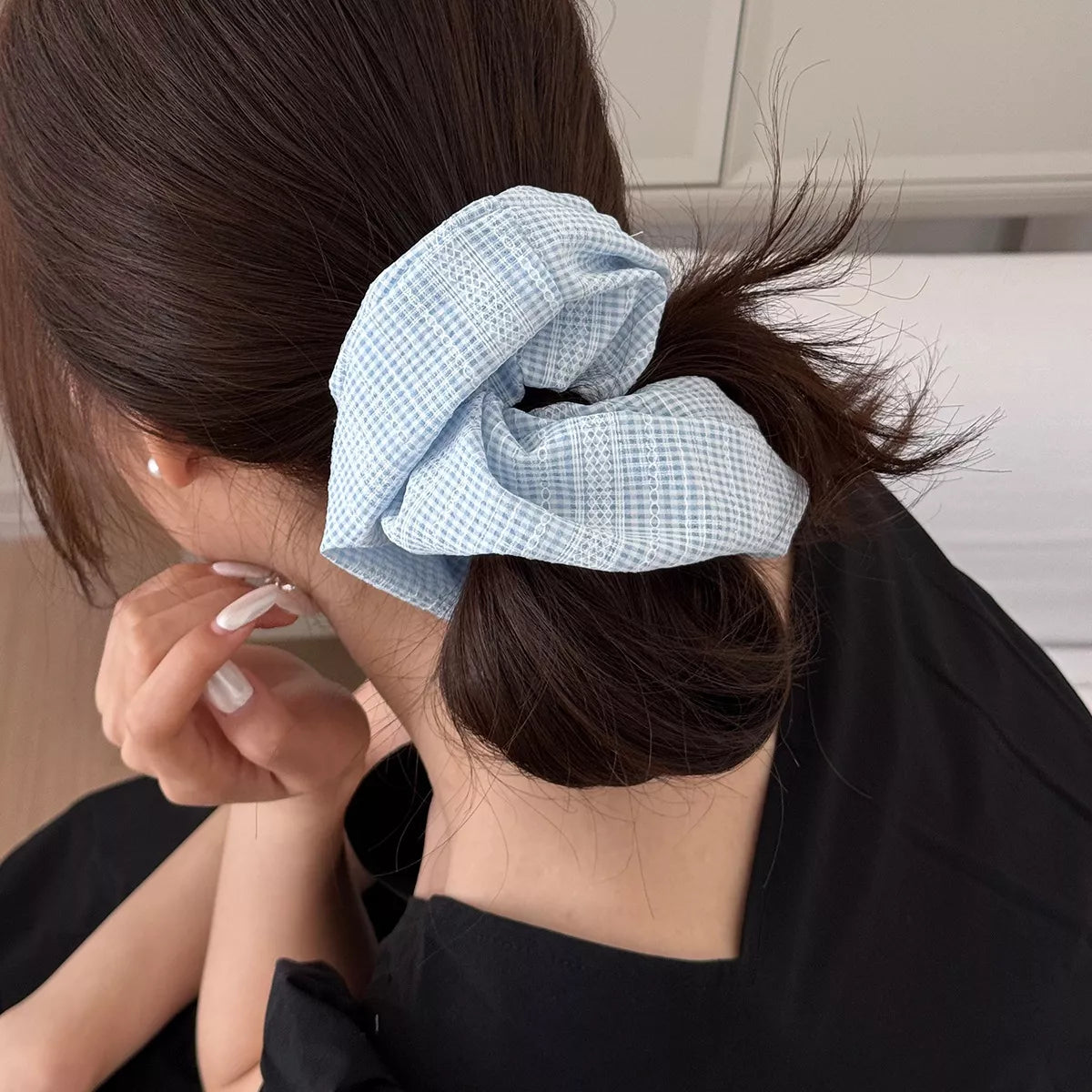 Light blue gingham scrunchie on ponytail side, tied bow shape
