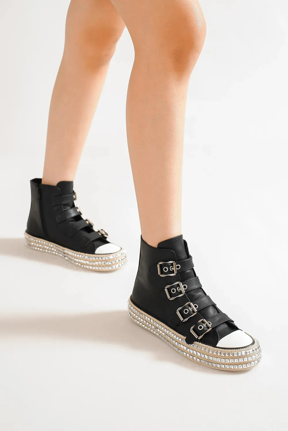 Black platform sneakers with studded sole, multi-buckle straps and white toe