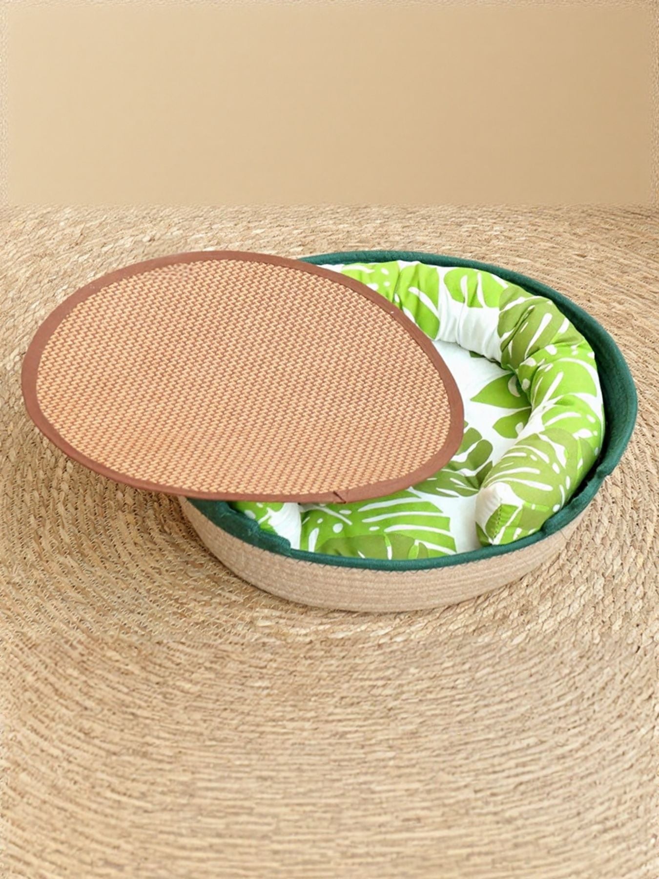 Woven Pet Nest with green leaf patterned cushion and green woven rim, oval basket