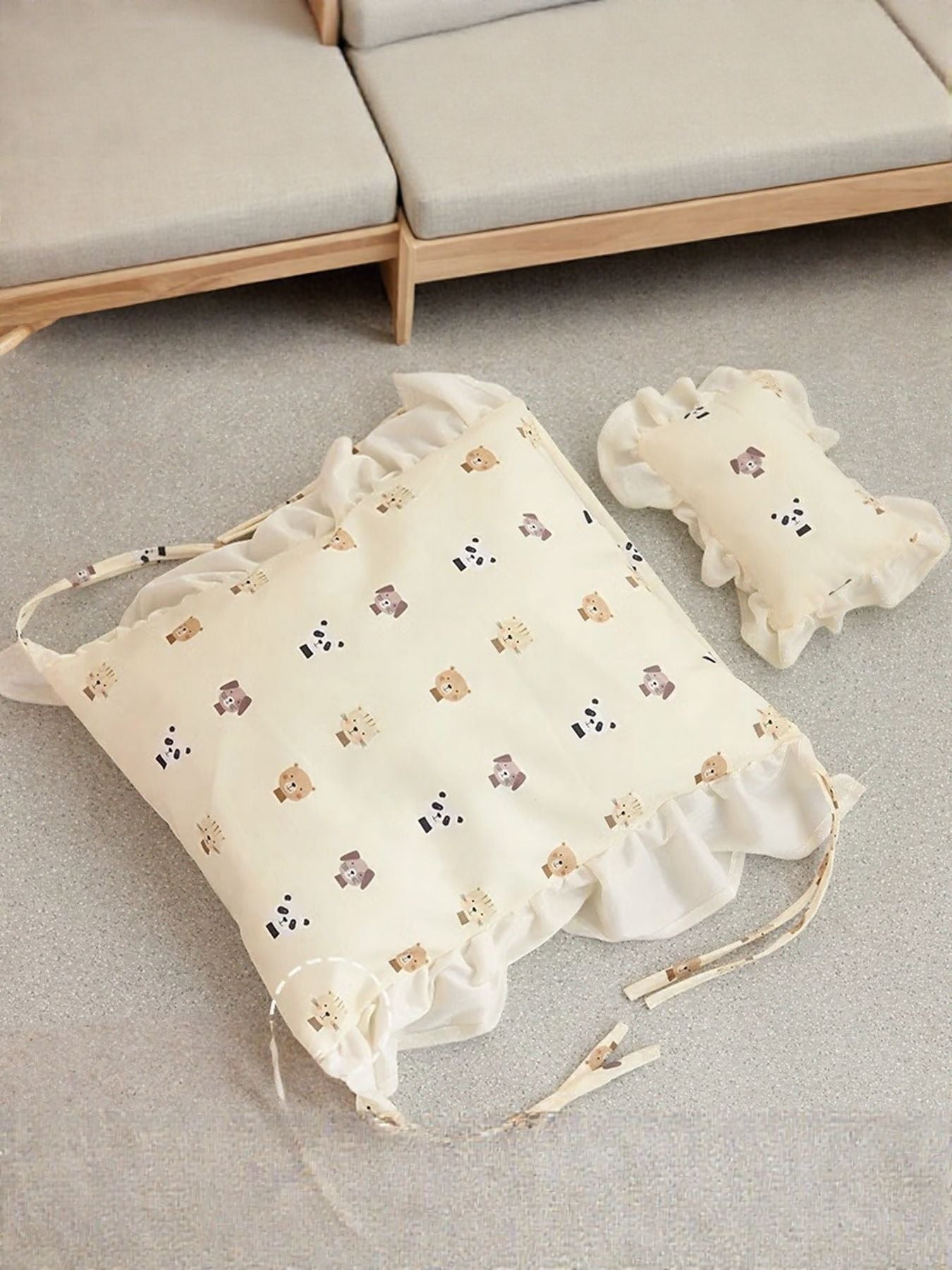 Wooden pet bed with folded bear-pattern bedding set and matching pillow.