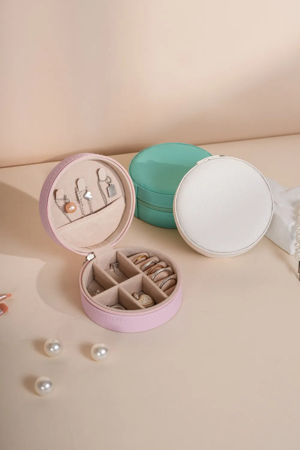 Blush pink round PU leather jewelry storage box, open with ring slots and earring spaces