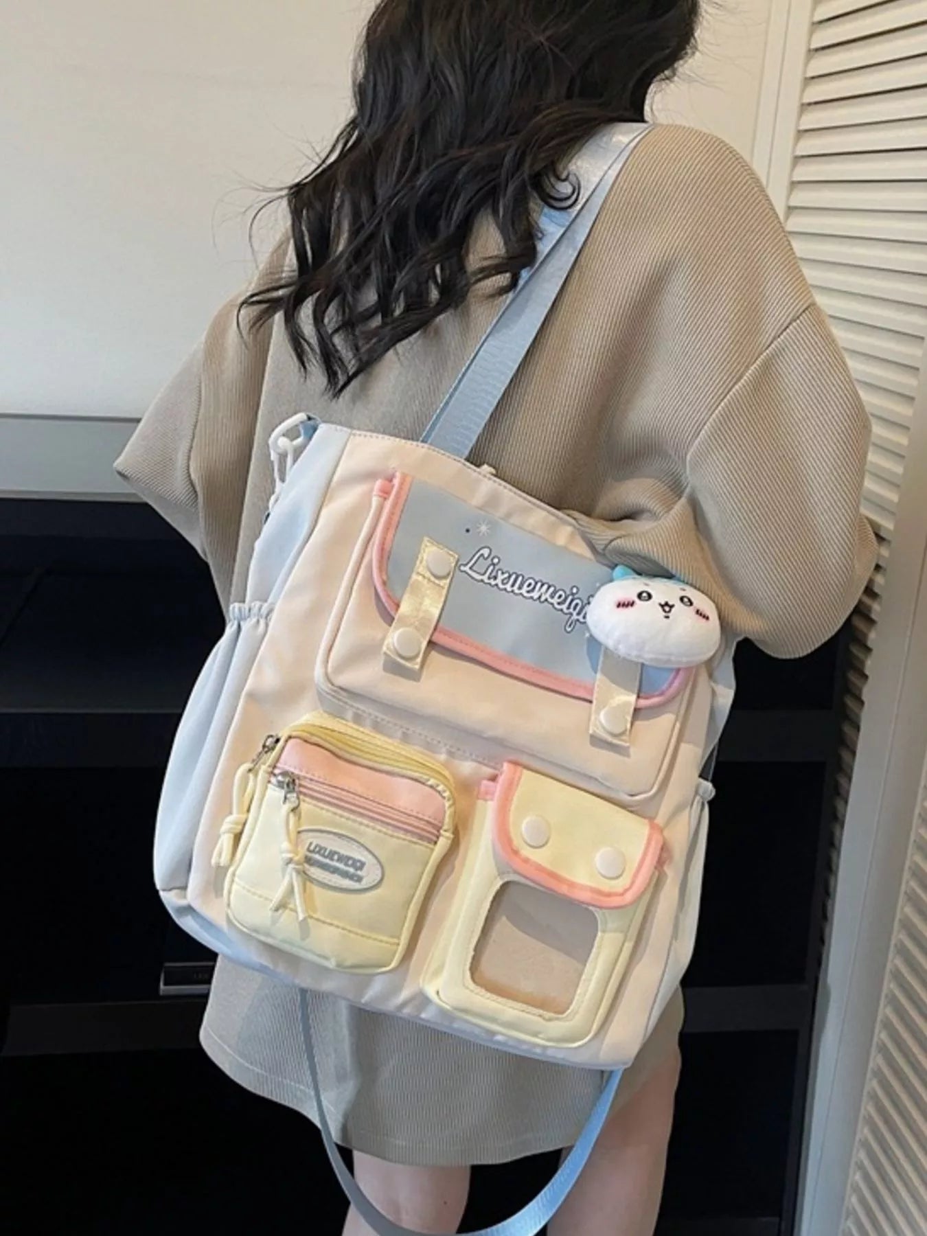 Multi-pocket shoulder bag worn on shoulder, plush charm, pastel blue strap, side zip pocket