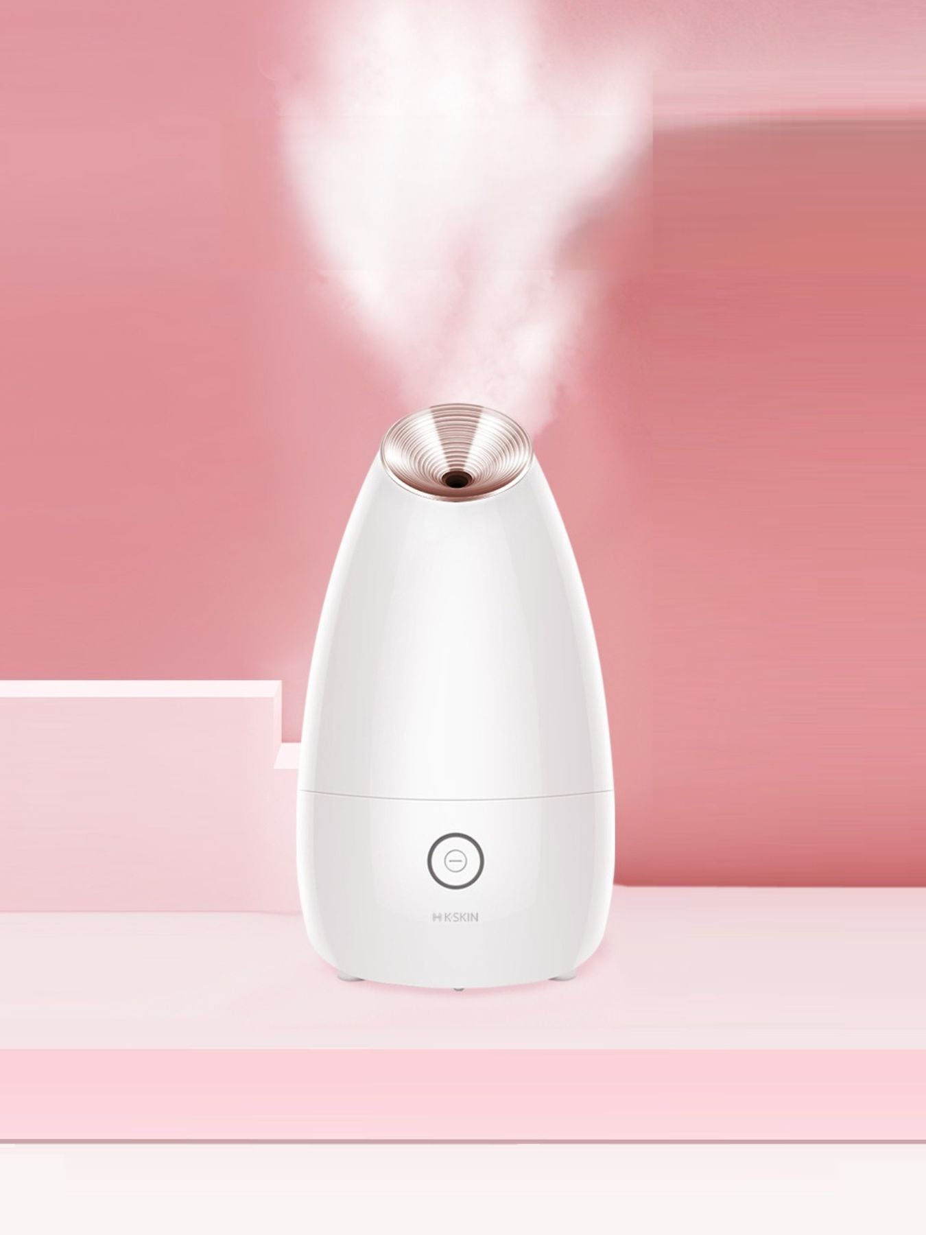 White facial steamer with rose-gold nozzle emitting steam