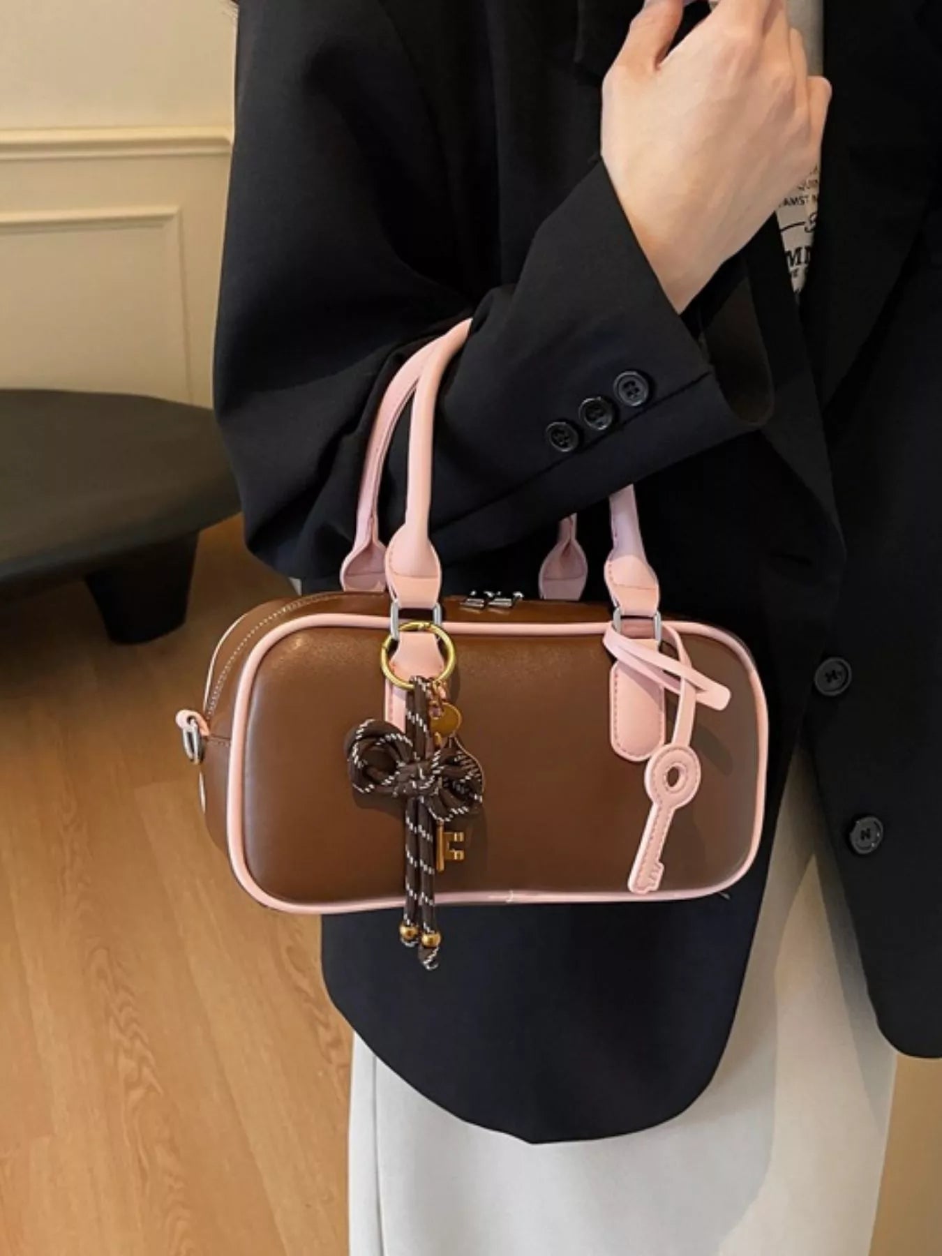 Barrel Crossbody Bag mit Schlüsselanhänger, braunes Fach und rosafarbene Riemen