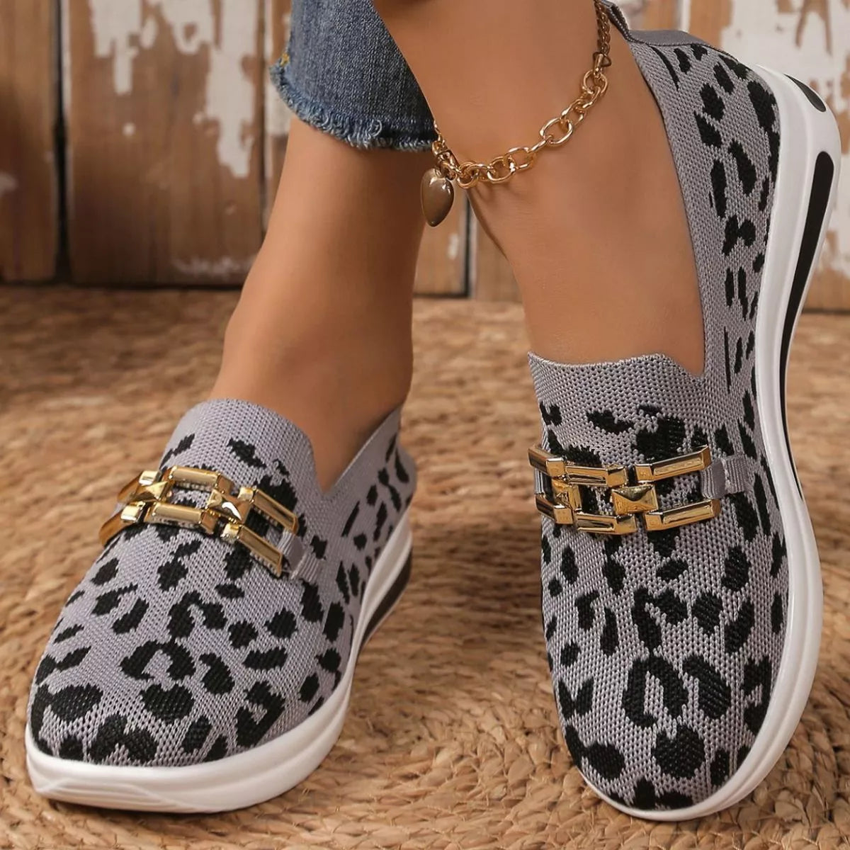 Gray leopard slip-ons with gold buckle ornament across the front vamp