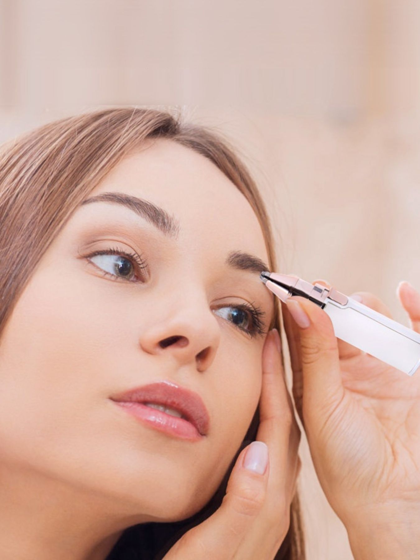 Beige eyebrow trimmer trimming facial hair near the brow line