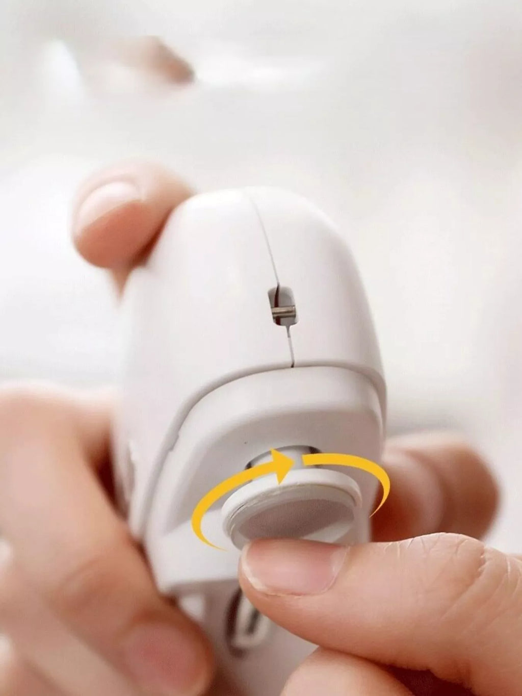 White electric nail buffer close-up showing circular sanding drum
