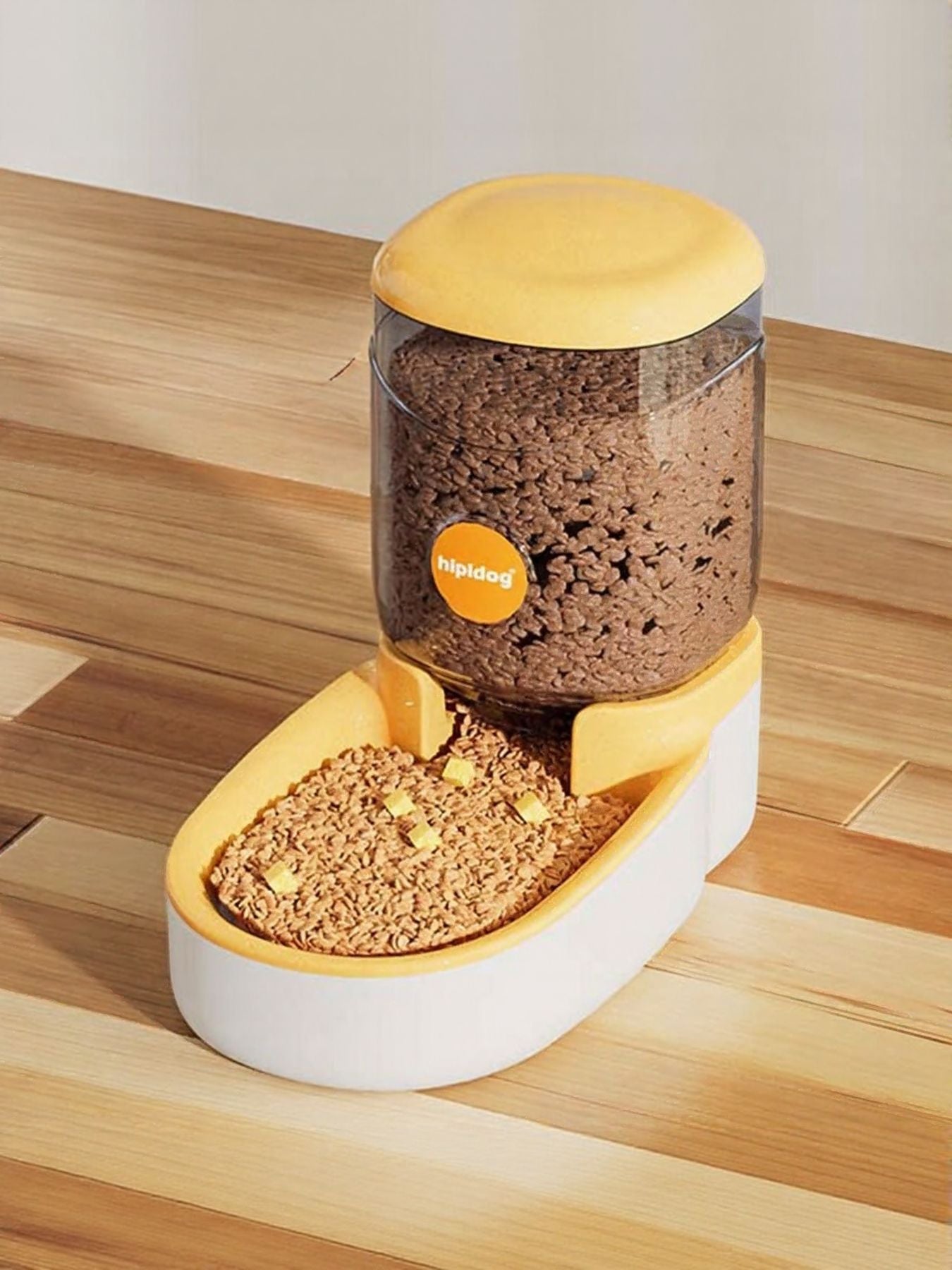Pastel yellow automatic pet food dispenser with clear container and white feeding tray