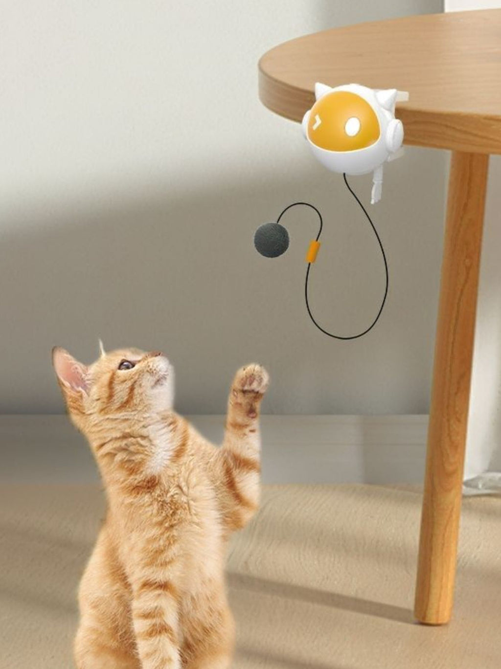Interactive hanging cat teaser toy with yellow-and-white head and gray dangling pom-ball
