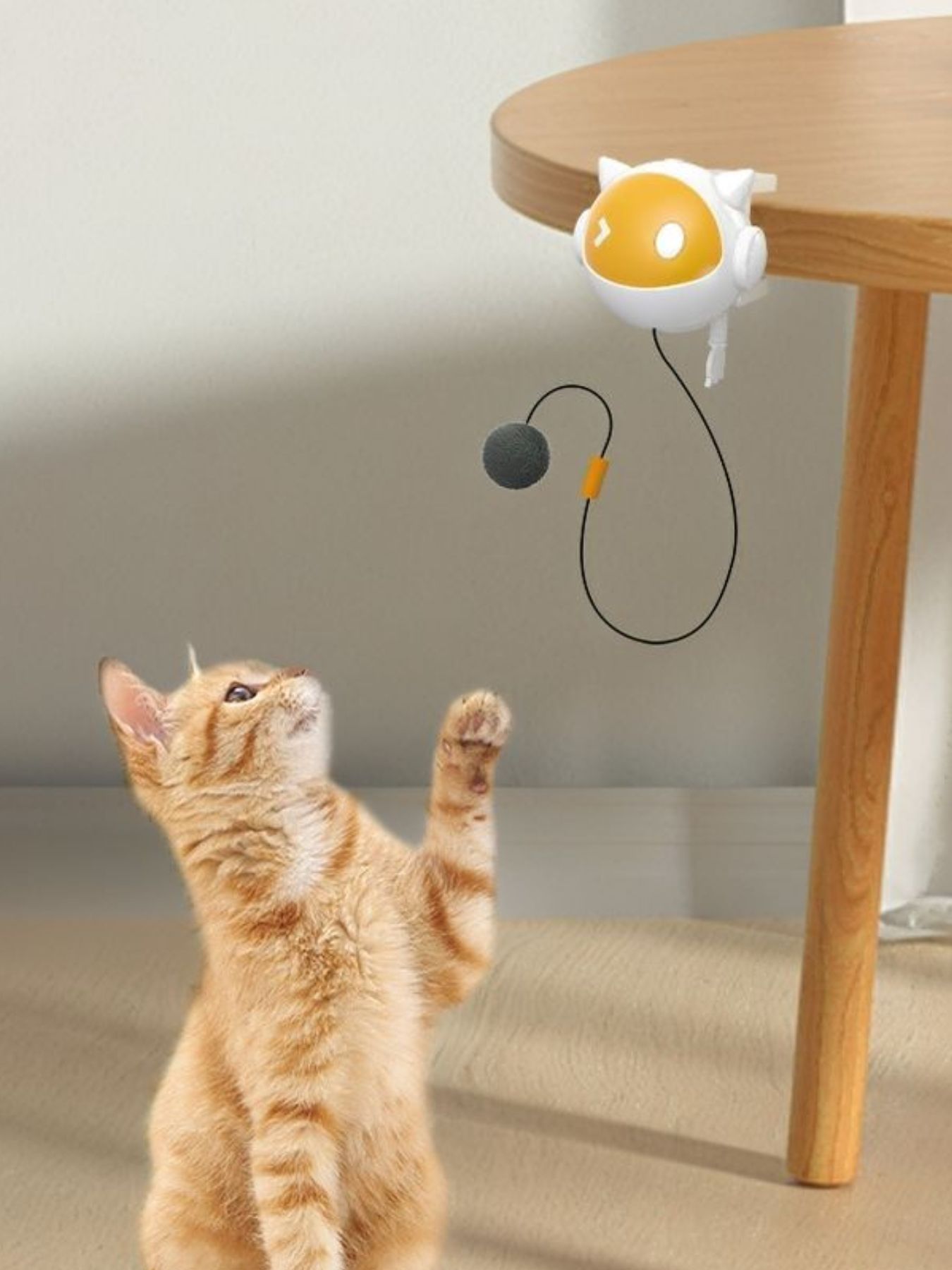 Interactive hanging cat teaser toy with yellow-and-white head and gray dangling pom-ball