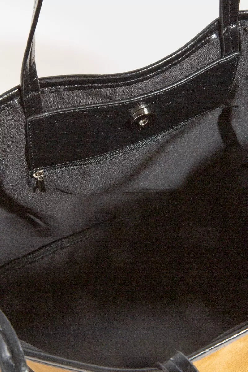 Black faux-leather trim interior view of tote with zipper pocket and snap hardware.