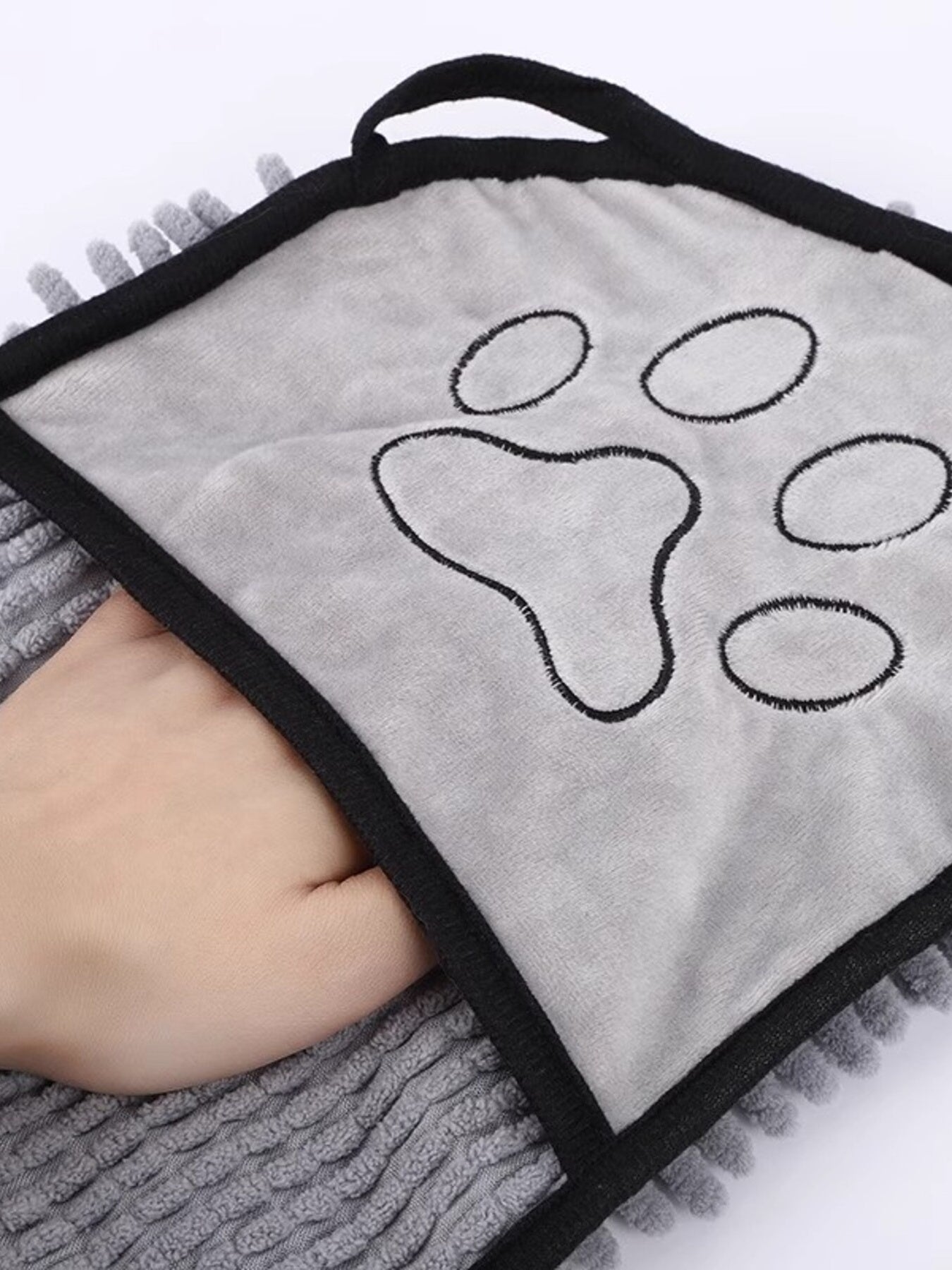 Paw Print Pet Towel gris plegado con huellas impresas y borde negro