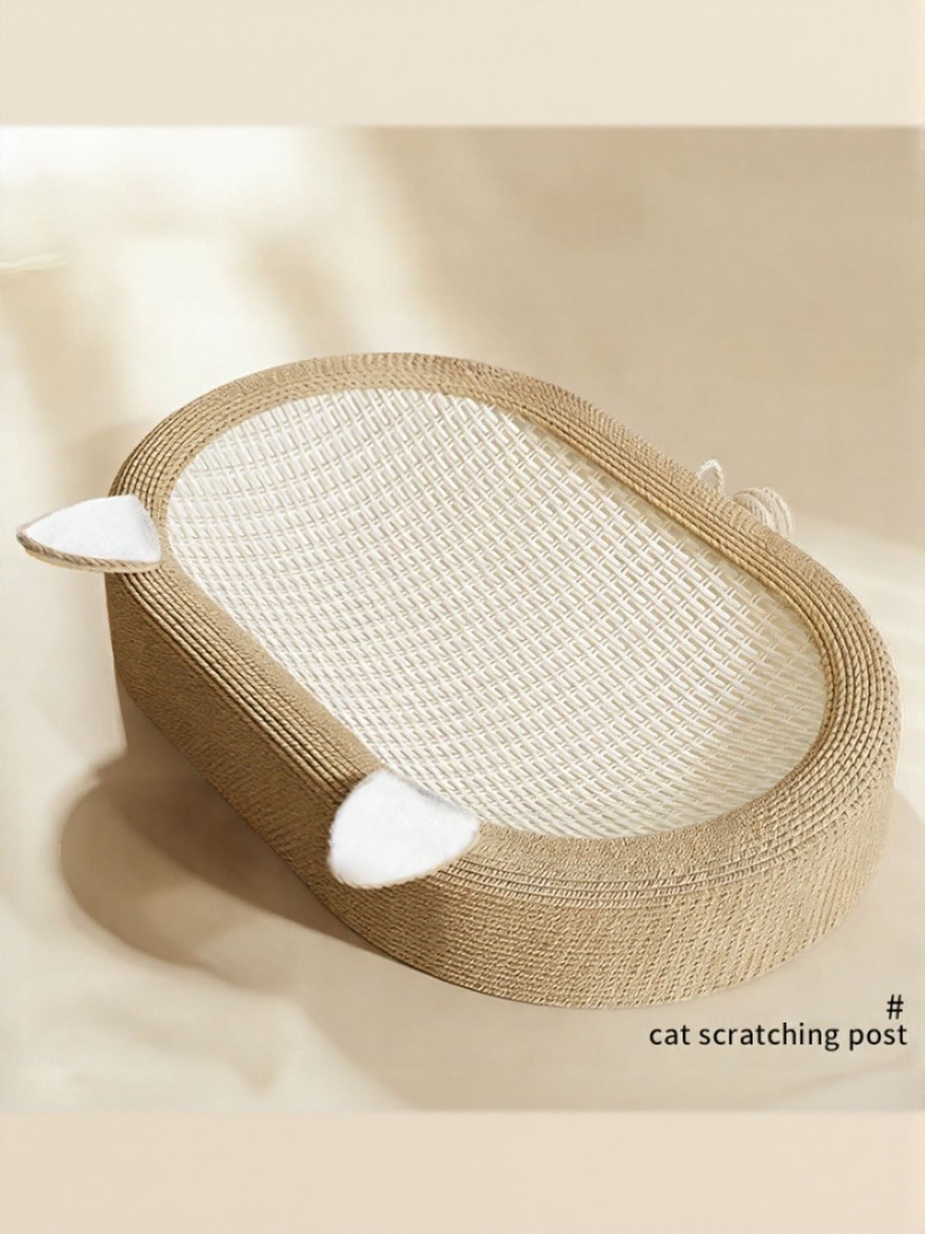 Beige oval scratching bed with white cat resting near the rim