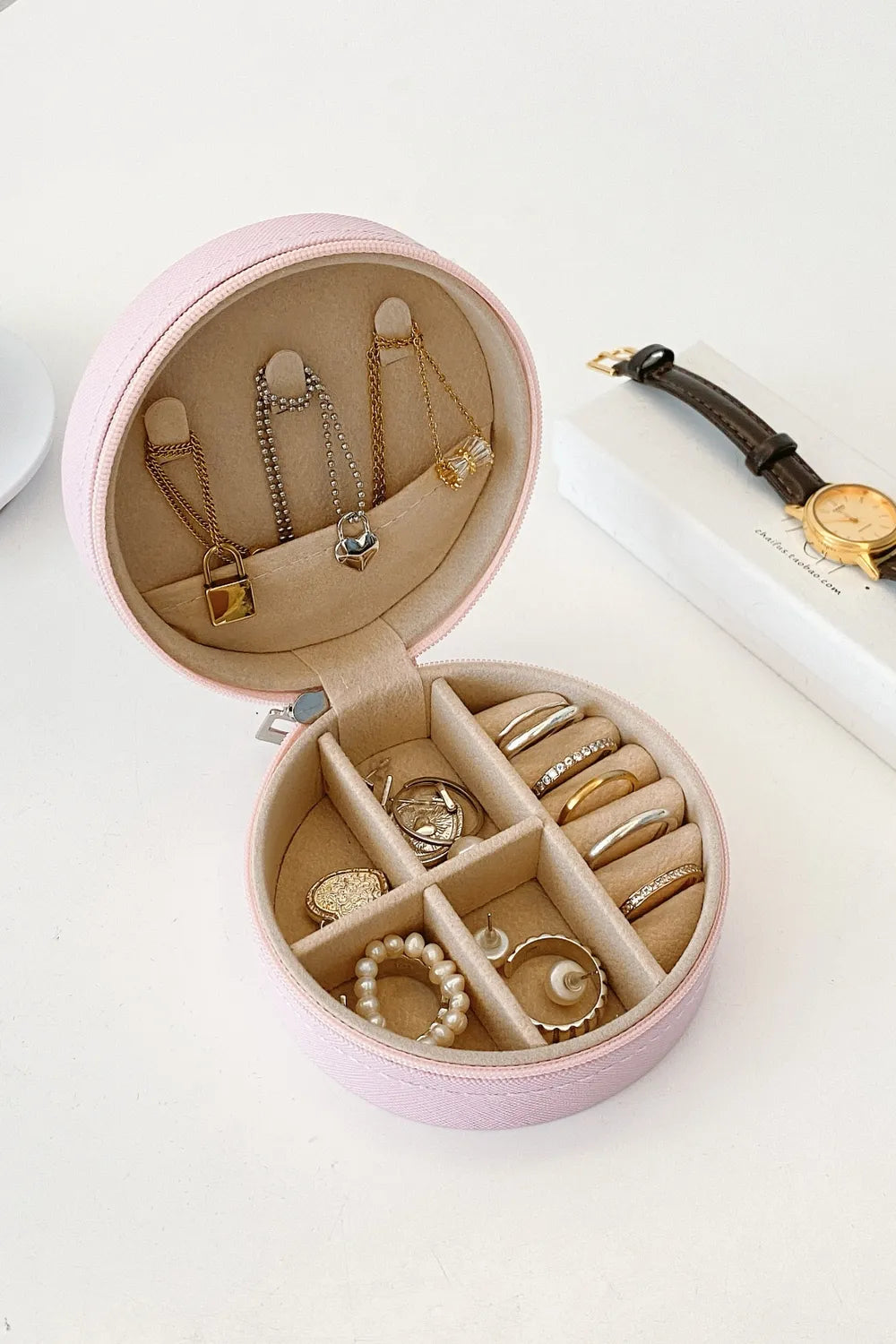 Blush pink PU leather jewelry storage box, open with ring slots and earring compartments
