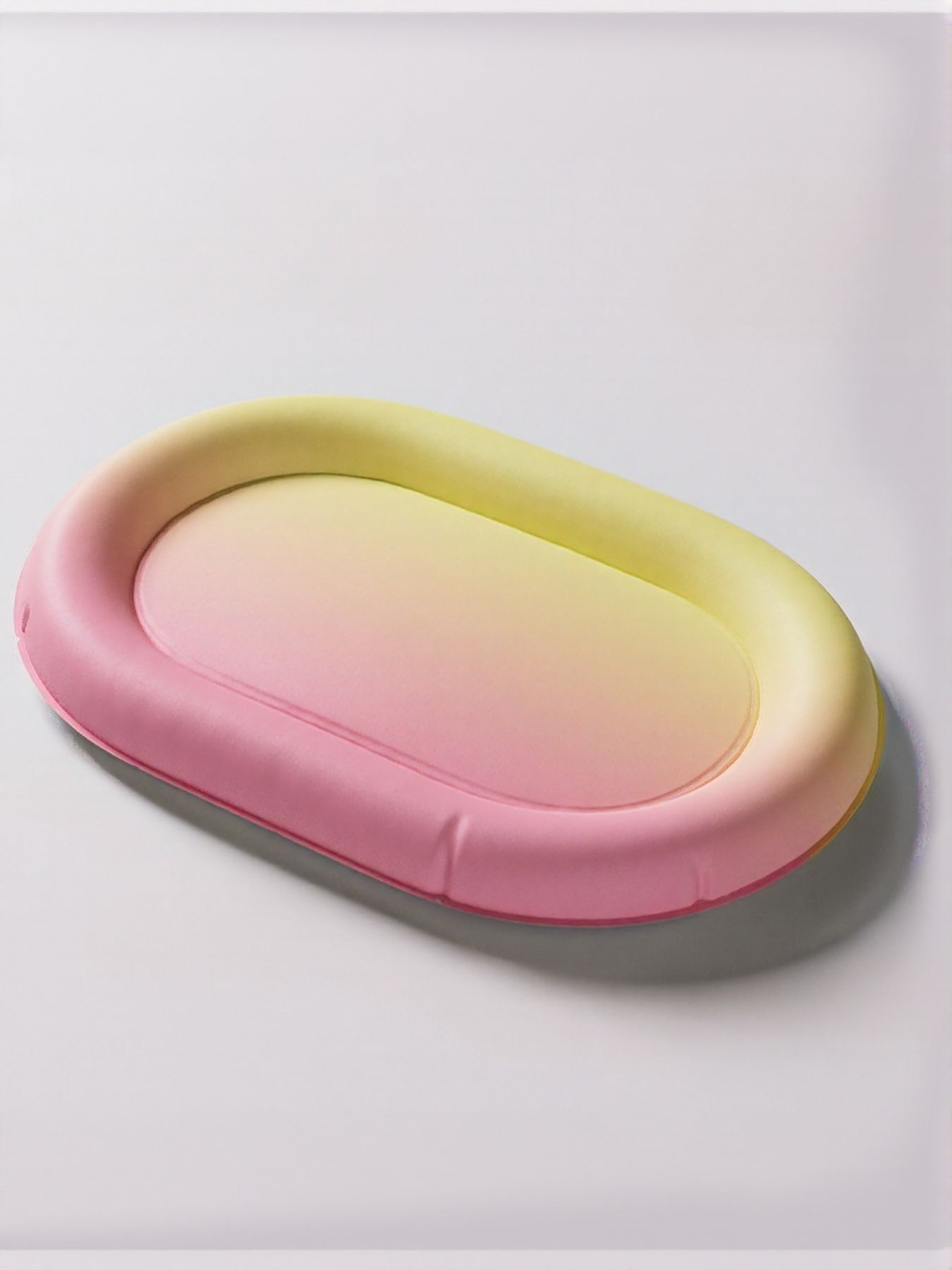 Pet Ice Nest oval lounging bed with pink and yellow gradient cushioned rim