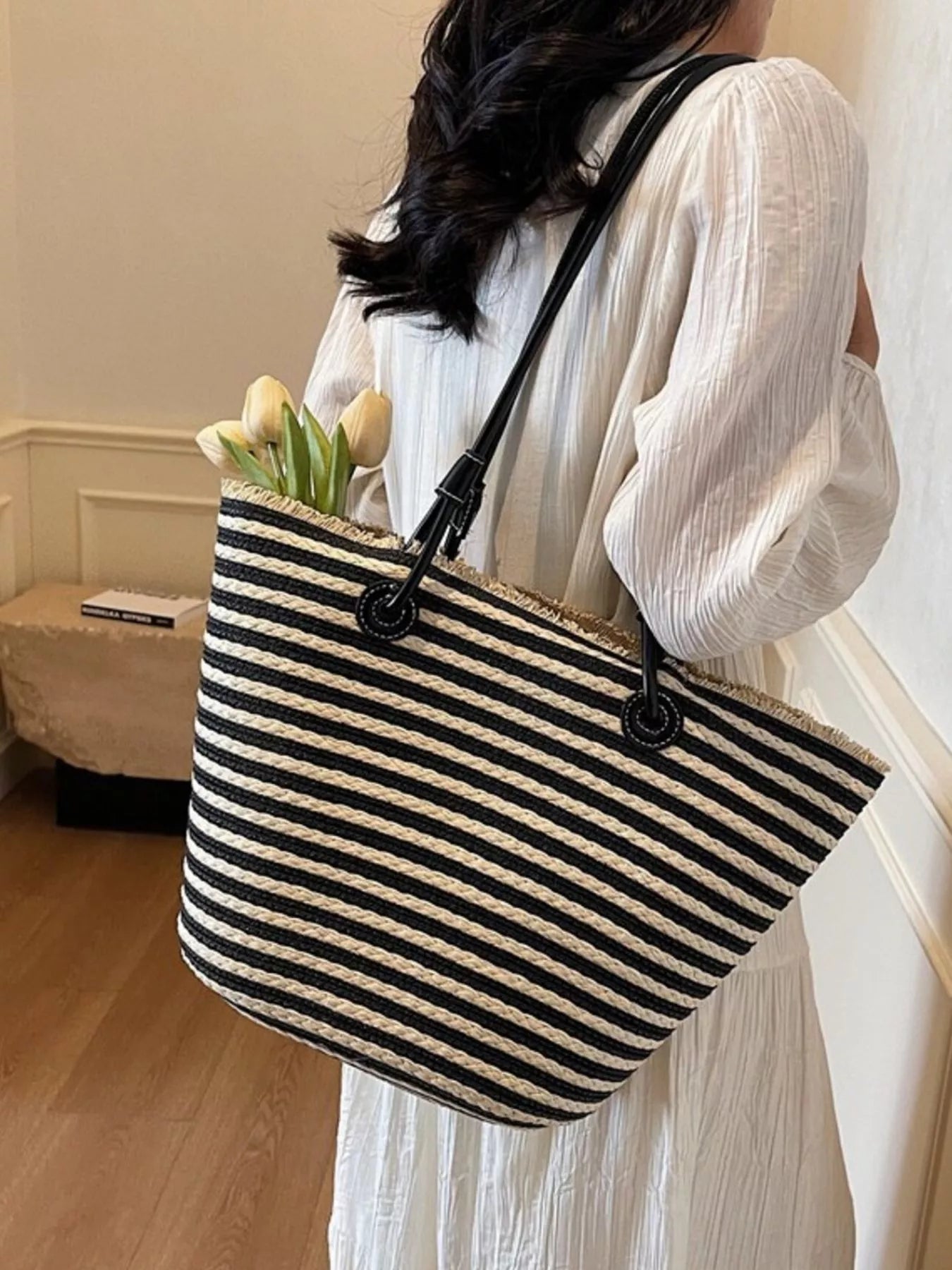 Striped woven straw shoulder bag in black and cream with round ring handle detail