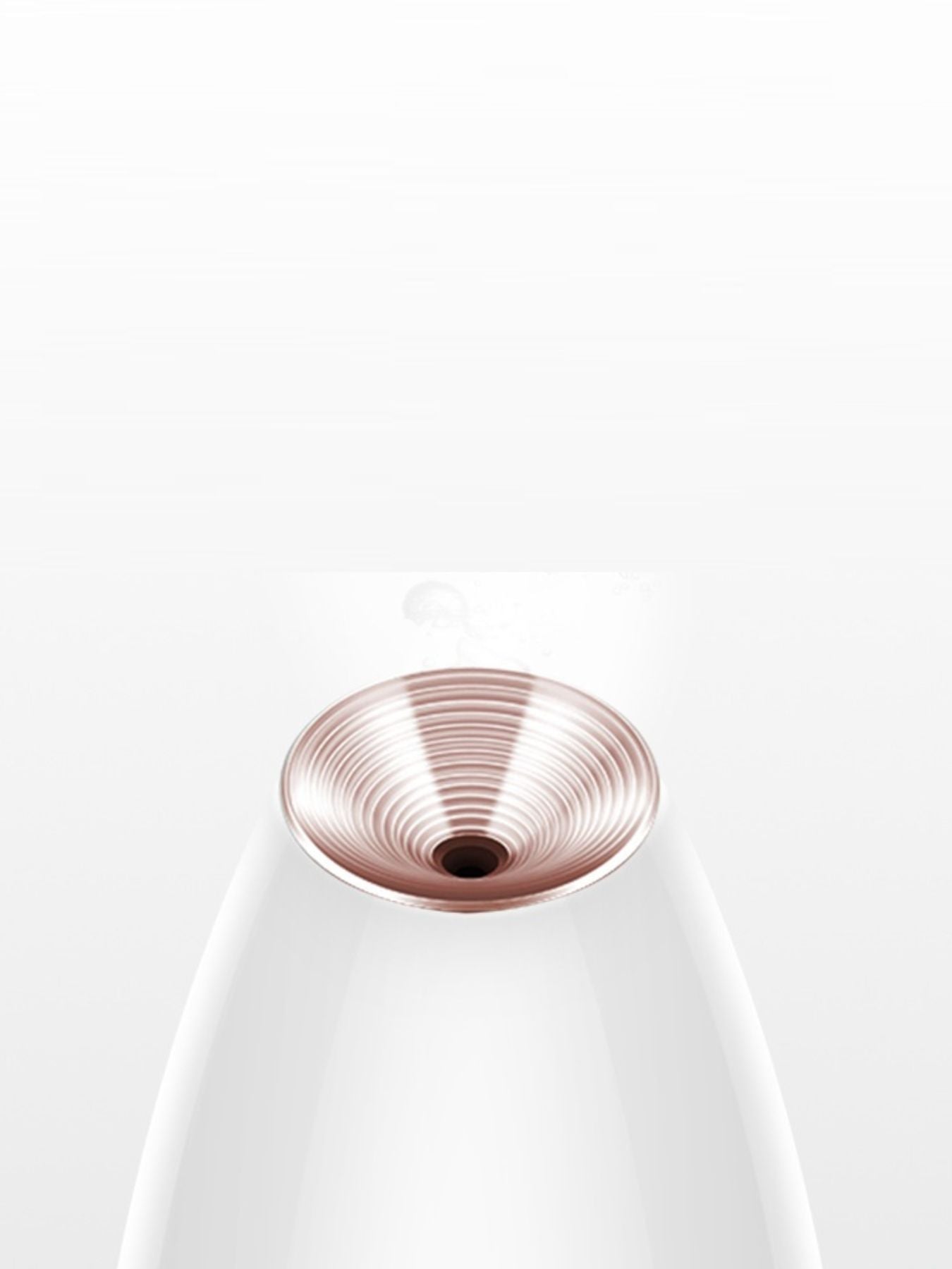 Close-up rose-gold steam nozzle on white facial steamer