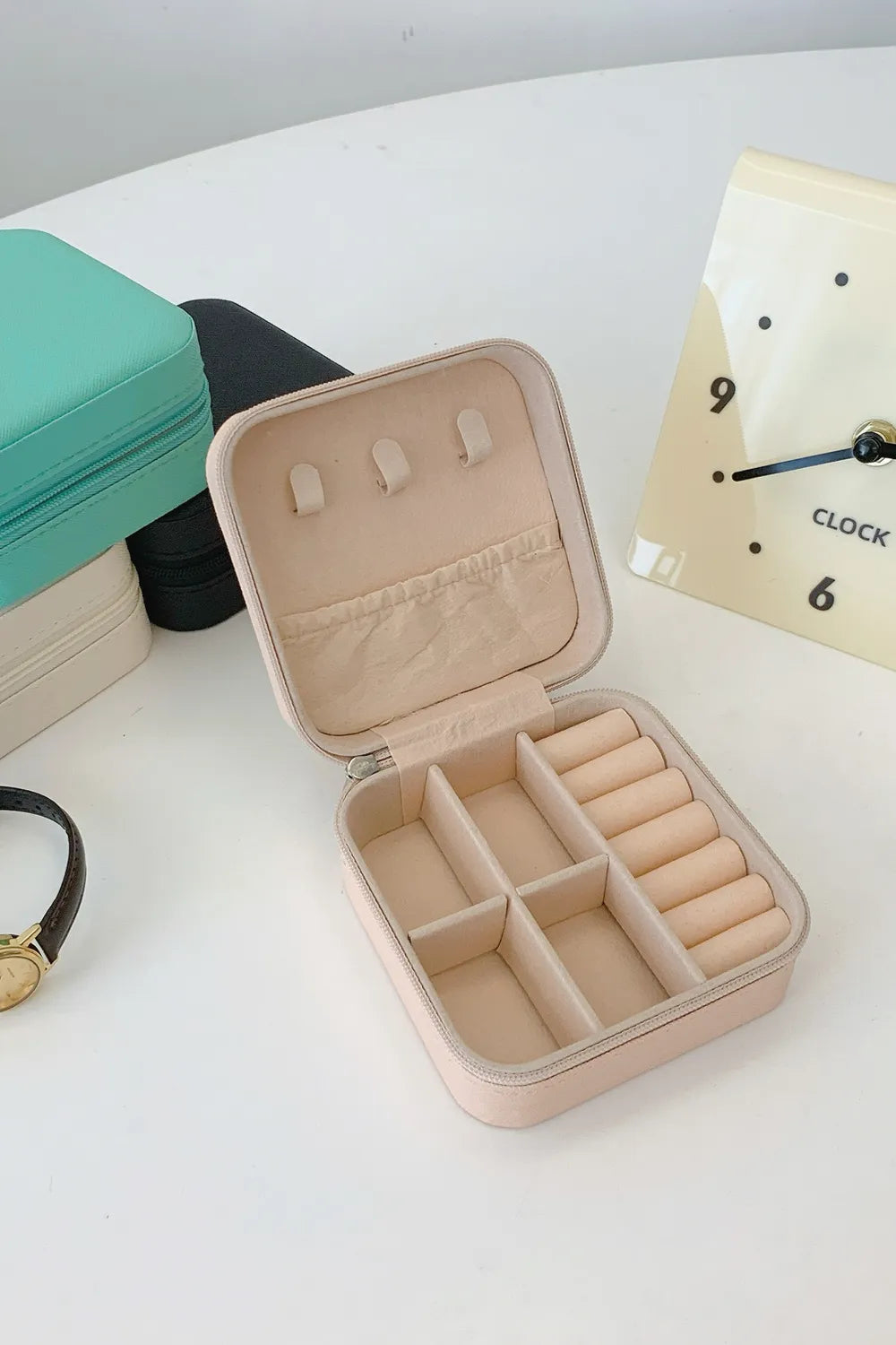 Blush pink PU leather square jewelry box, open with padded ring sections and earring slots