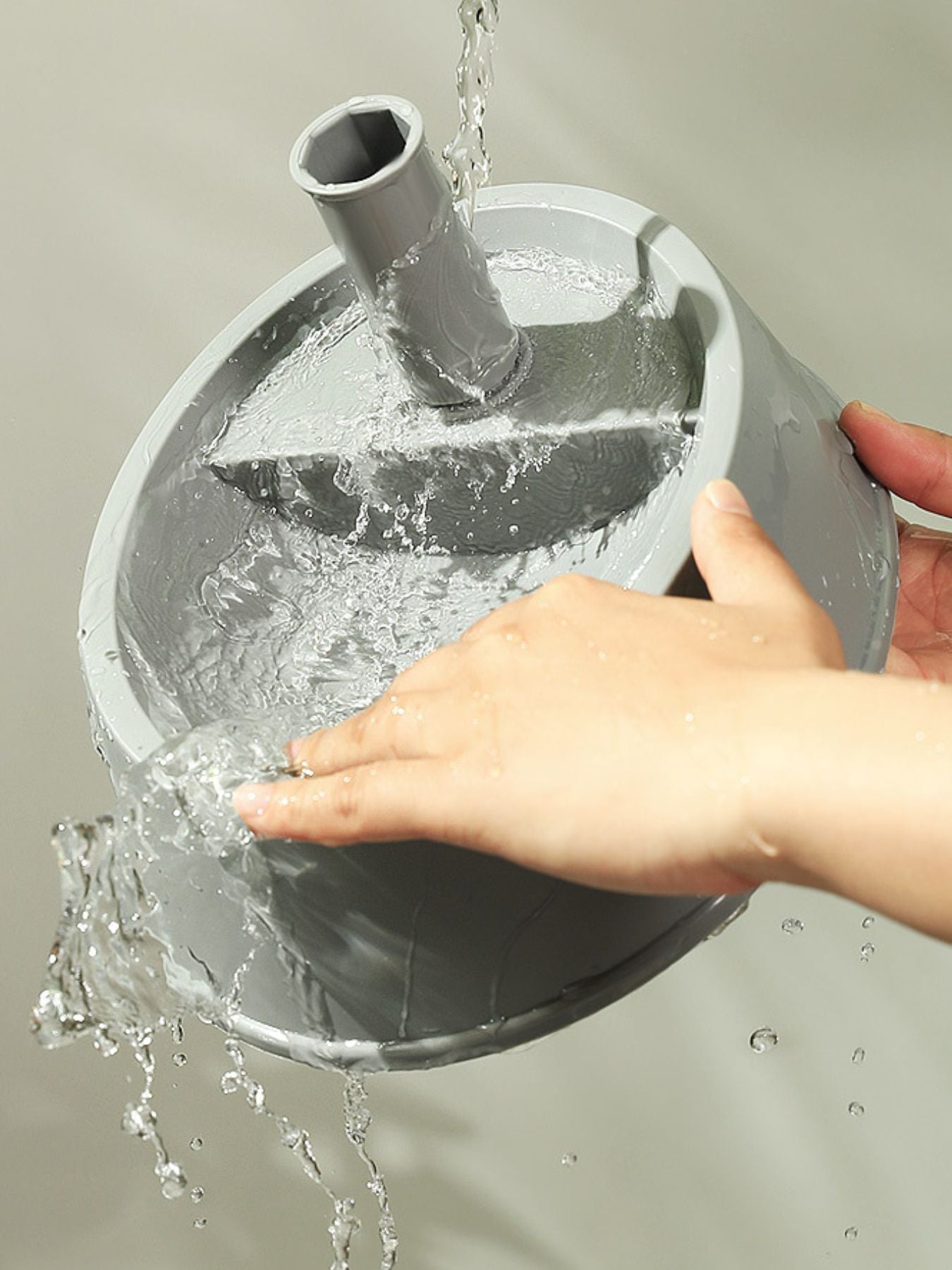 Water pouring into the reservoir of an automatic water dispenser pet bowl
