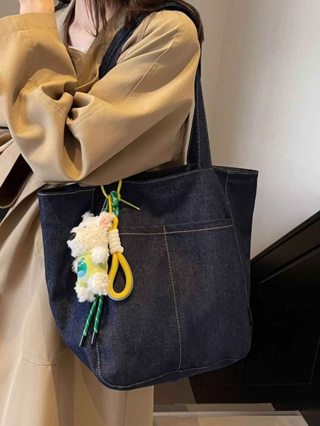 Navy denim tote with plush keychain charm hanging from front side pocket