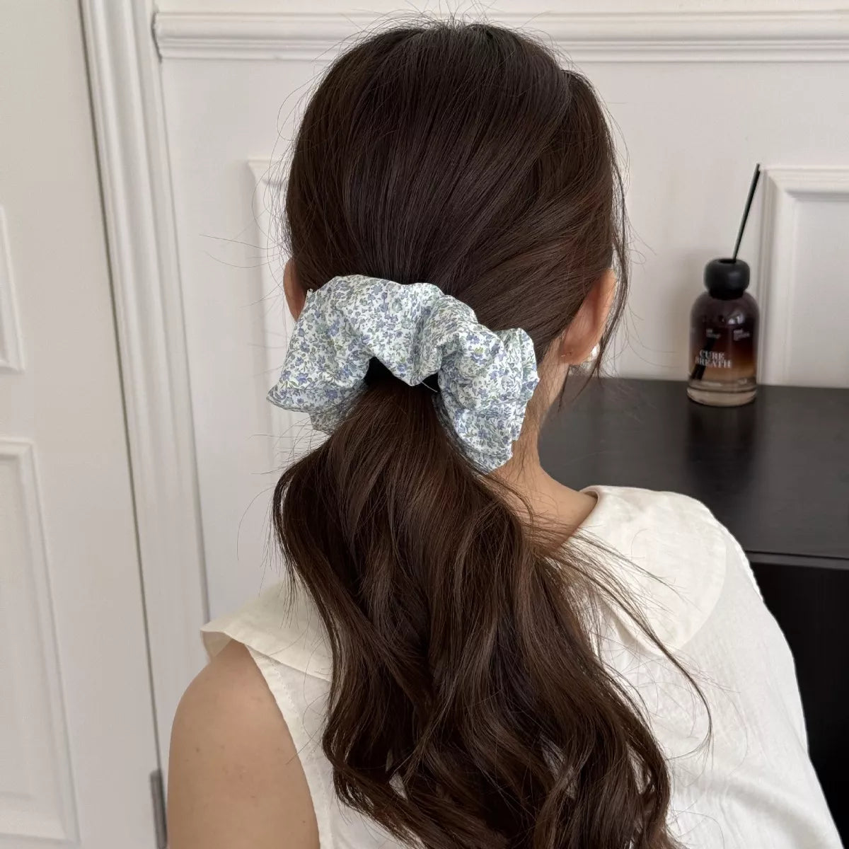 Blue floral hair scrunchie on brown ponytail