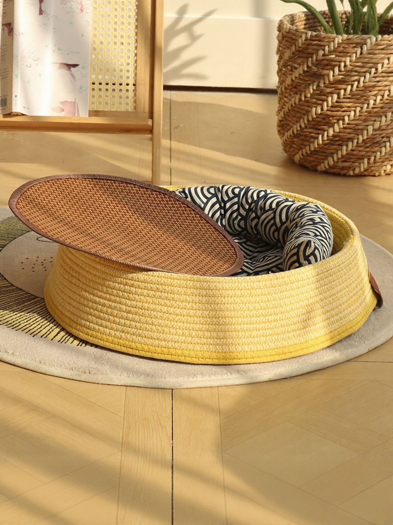 Woven rattan pet nest with yellow woven rim, zebra-print cushion, brown oval lid