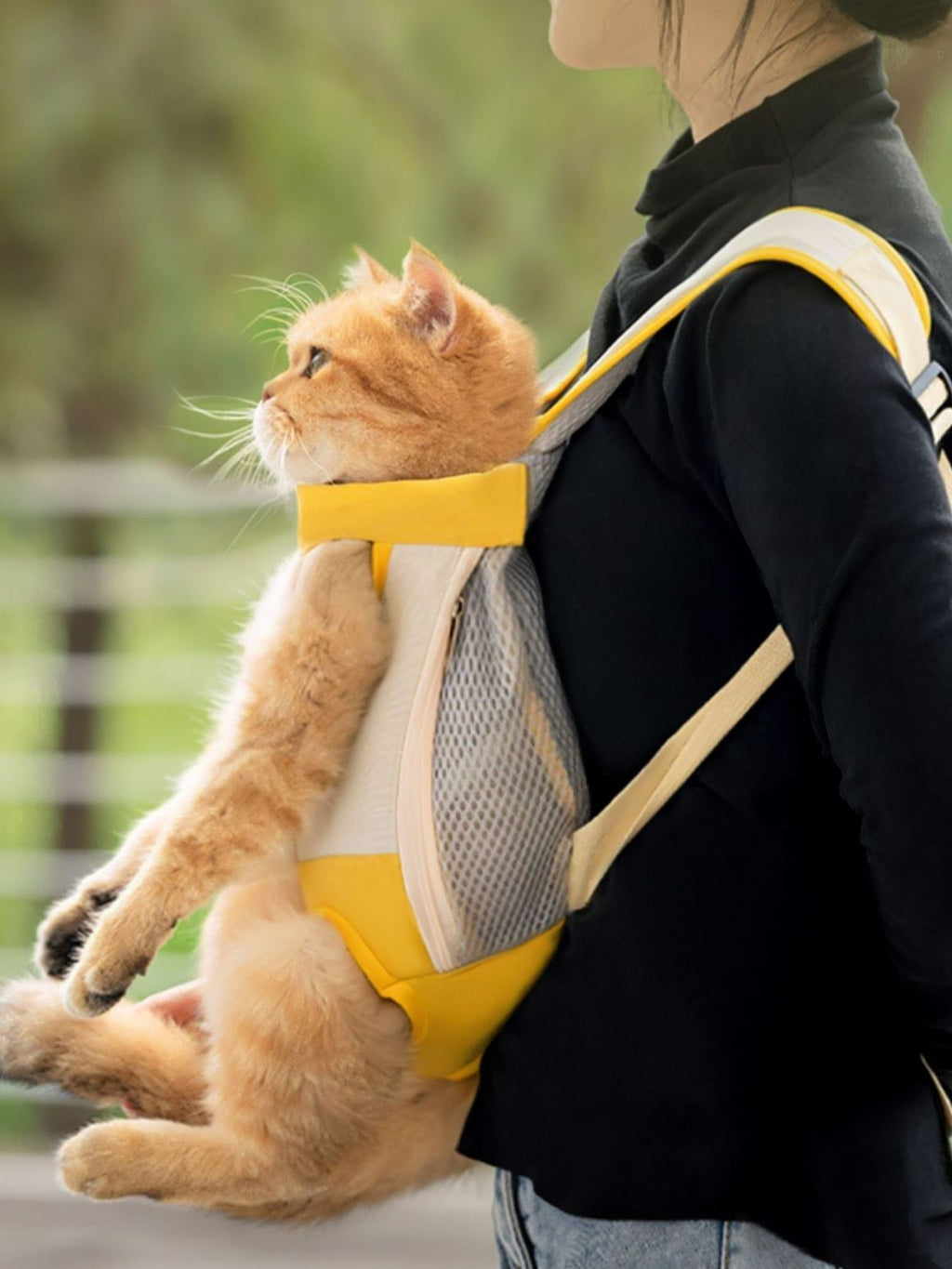 Front-pack pet carrier with yellow pocket and beige mesh panel, side view