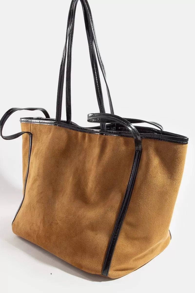 Tan suede tote bag with black trim and shoulder strap loops, angled side view.