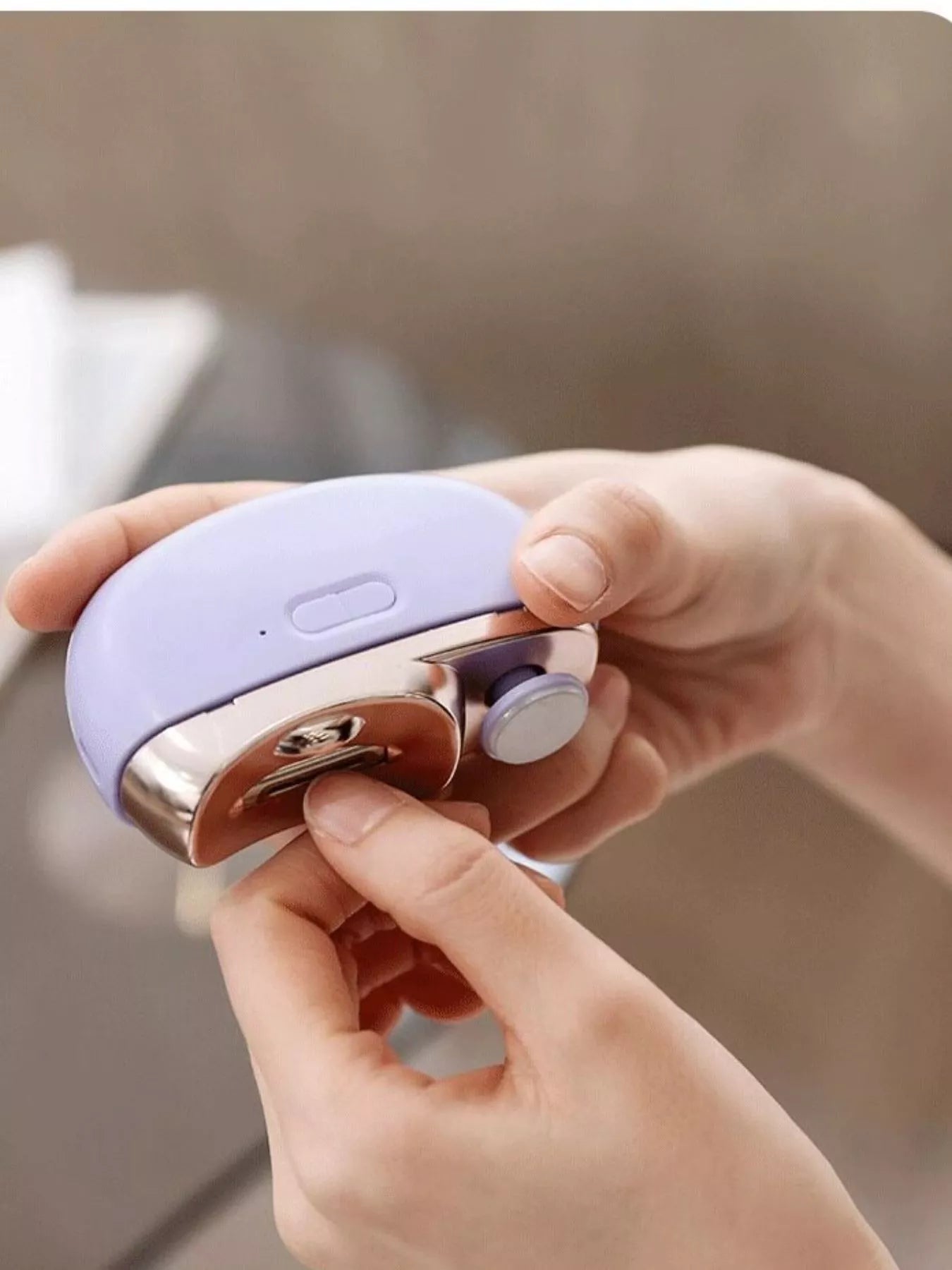 Electric nail buffer, lilac handheld device with power button and buffing roller