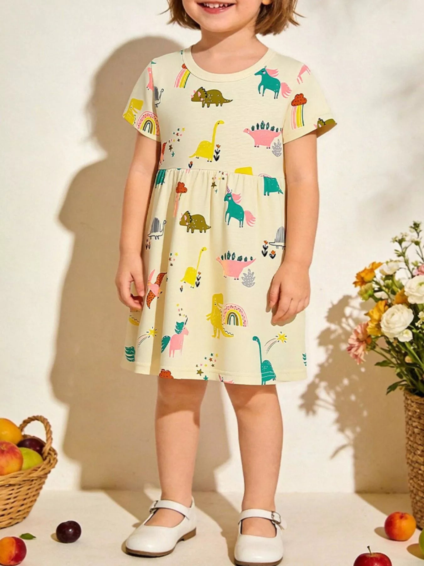 Kids casual dress in pastel yellow with cartoon dinosaur print, short sleeves