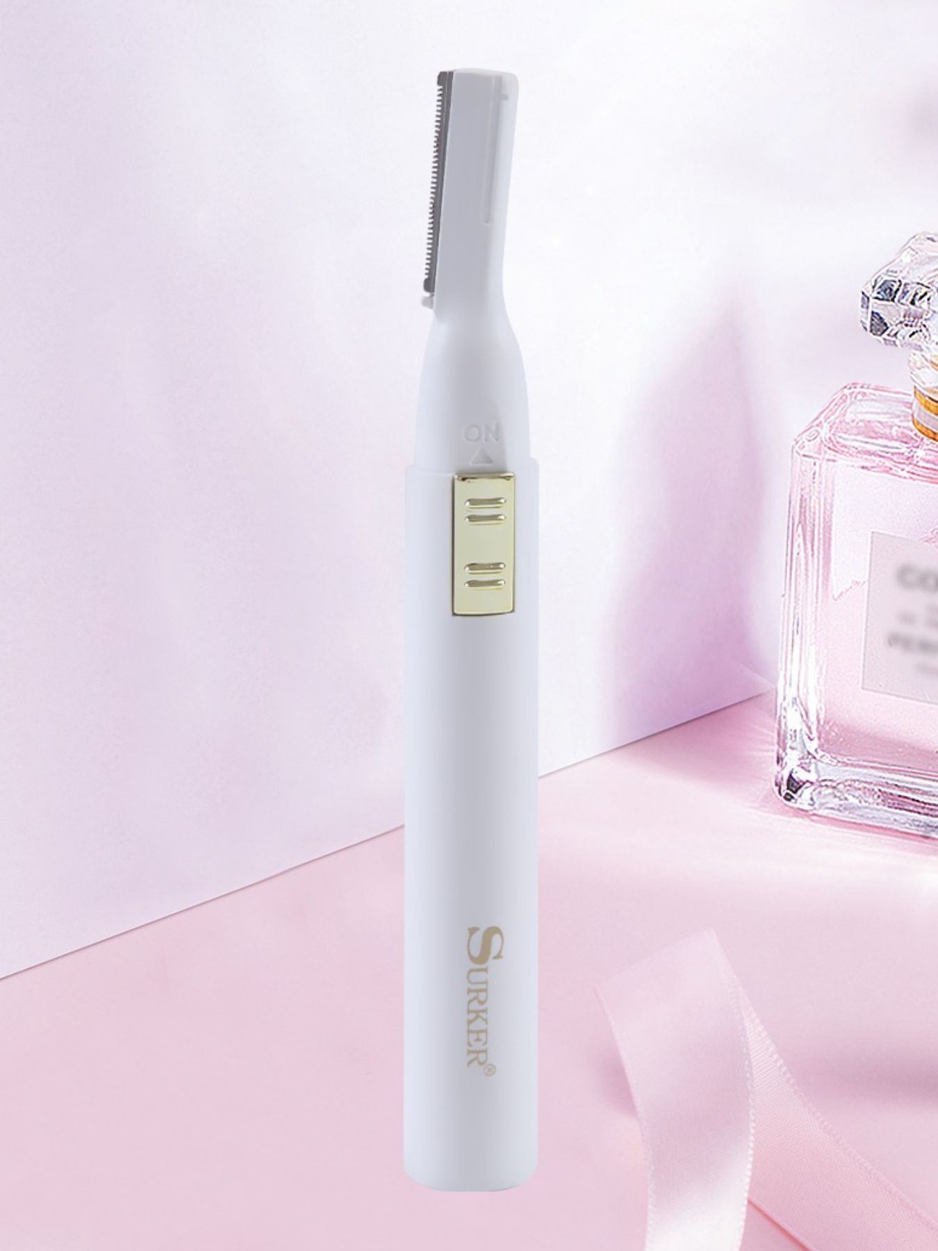 White eyebrow trimmer with gold-toned blade and guard