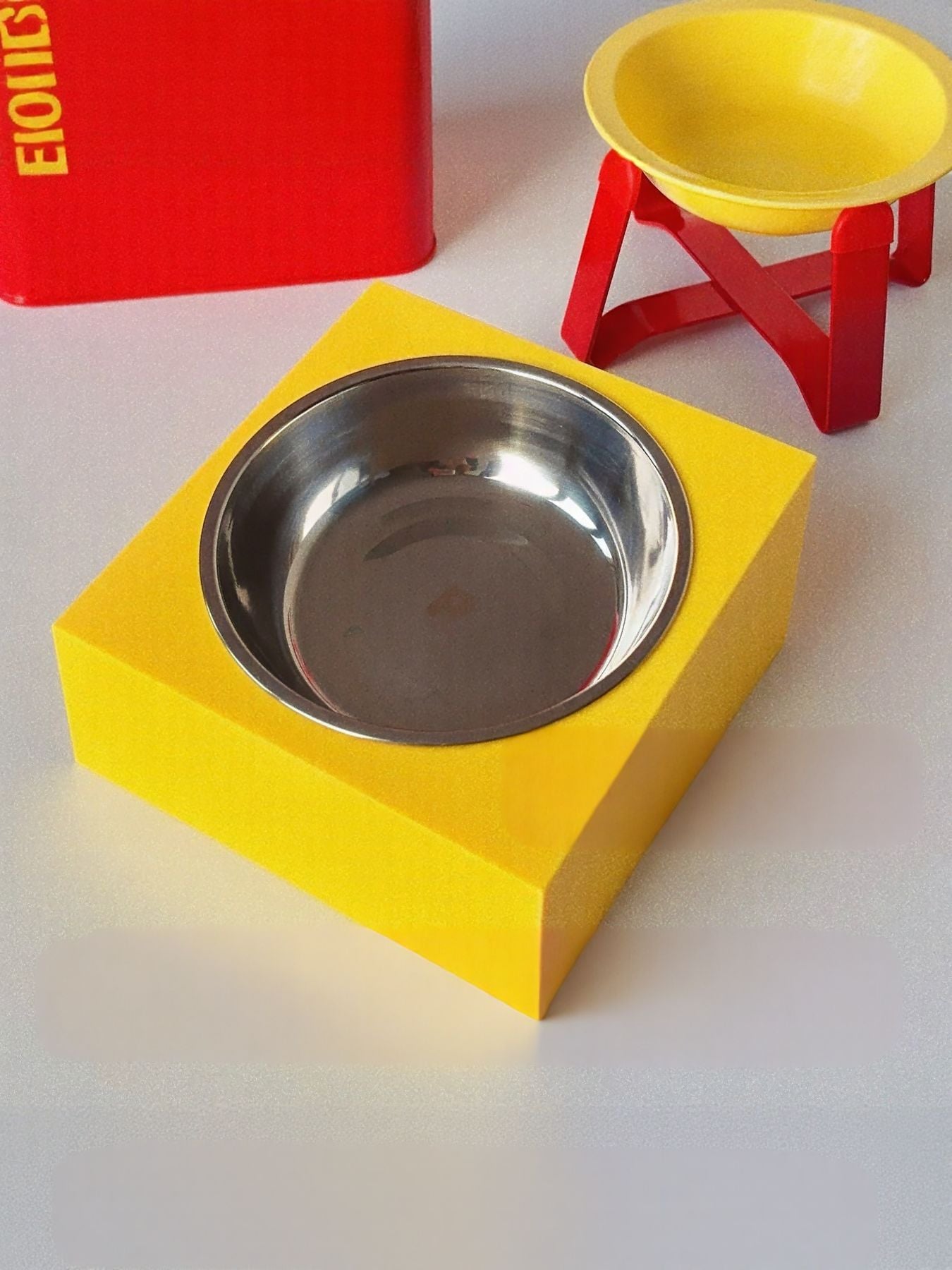 Yellow square base with stainless steel pet bowl and small red stand