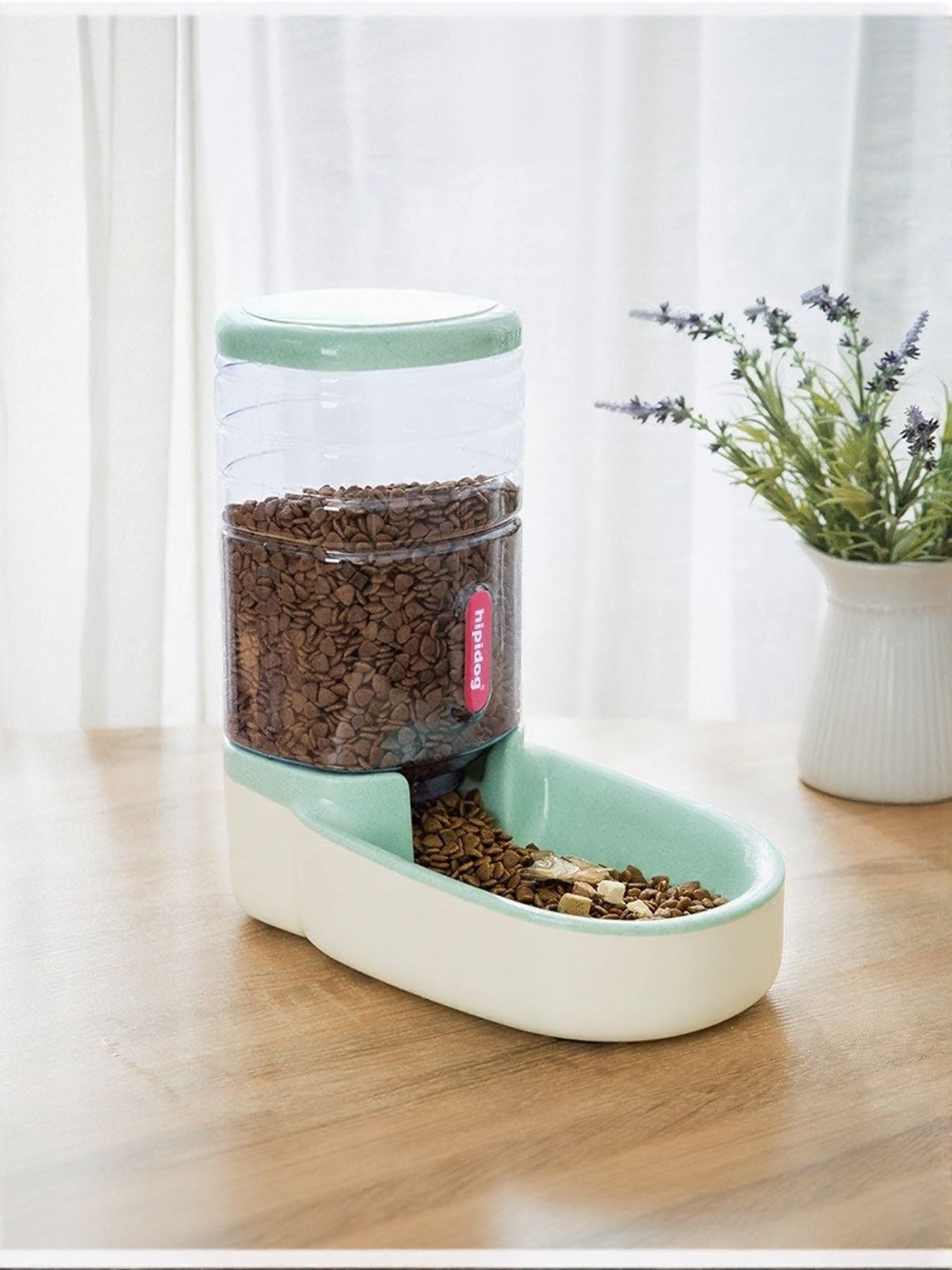 Mint green automatic pet food dispenser set with clear container filled with kibble